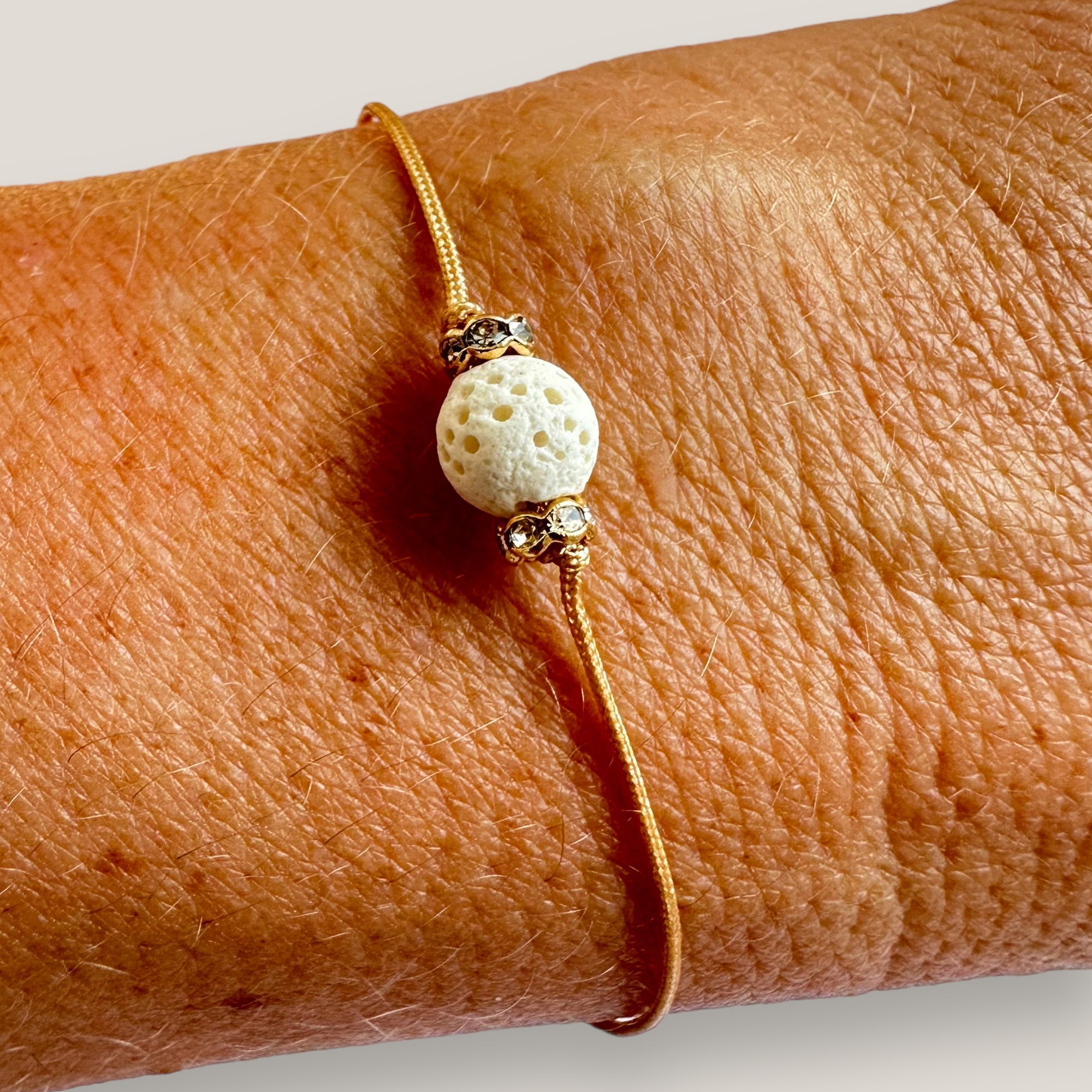Pulsera minimal con bola esponja coral blanco y cuentas doradas con brillis lux blancos