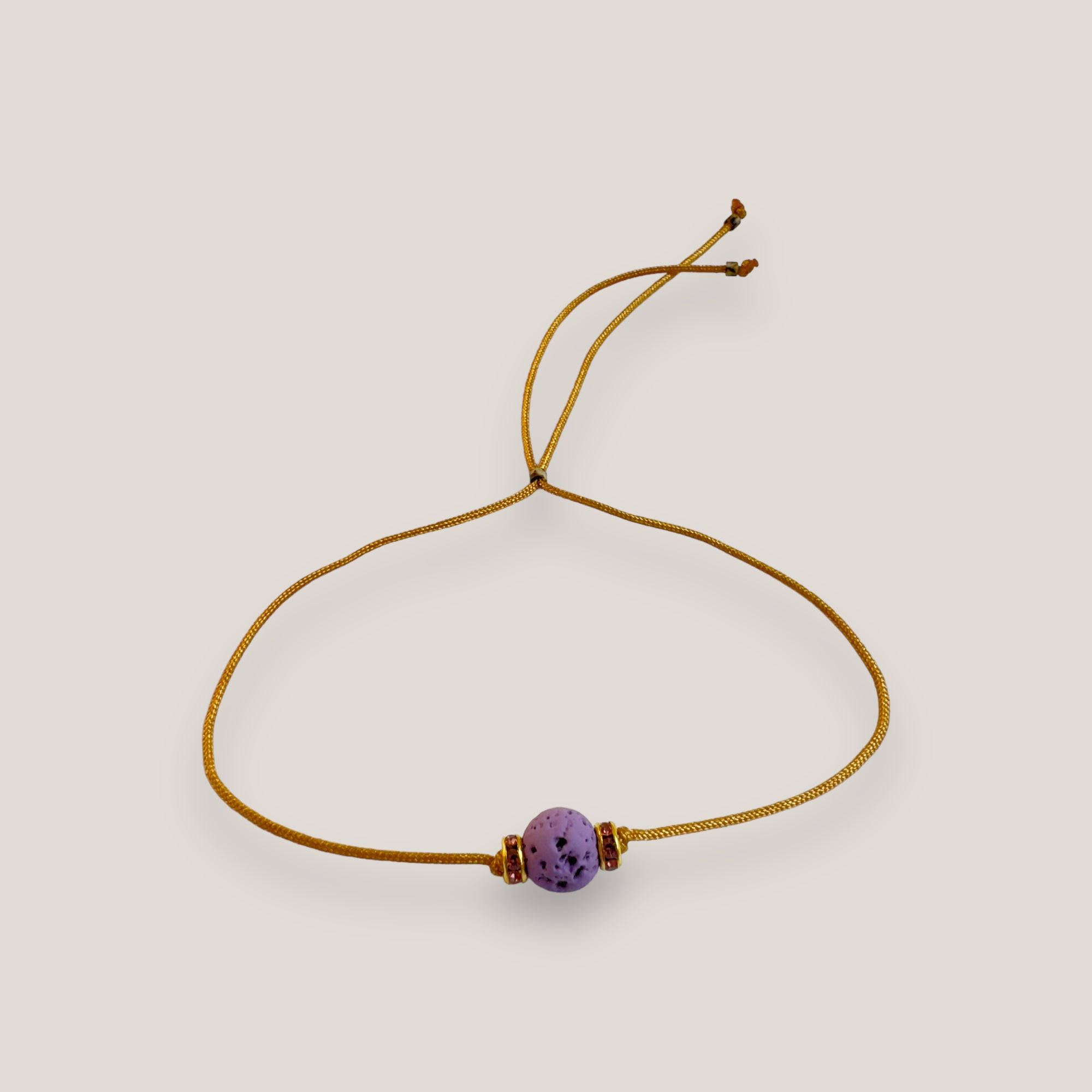 Pulsera minimal con bola de lava malva y cuentas doradas con brillis rosas