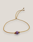 Pulsera minimal con bola de lava malva y cuentas doradas con brillis rosas