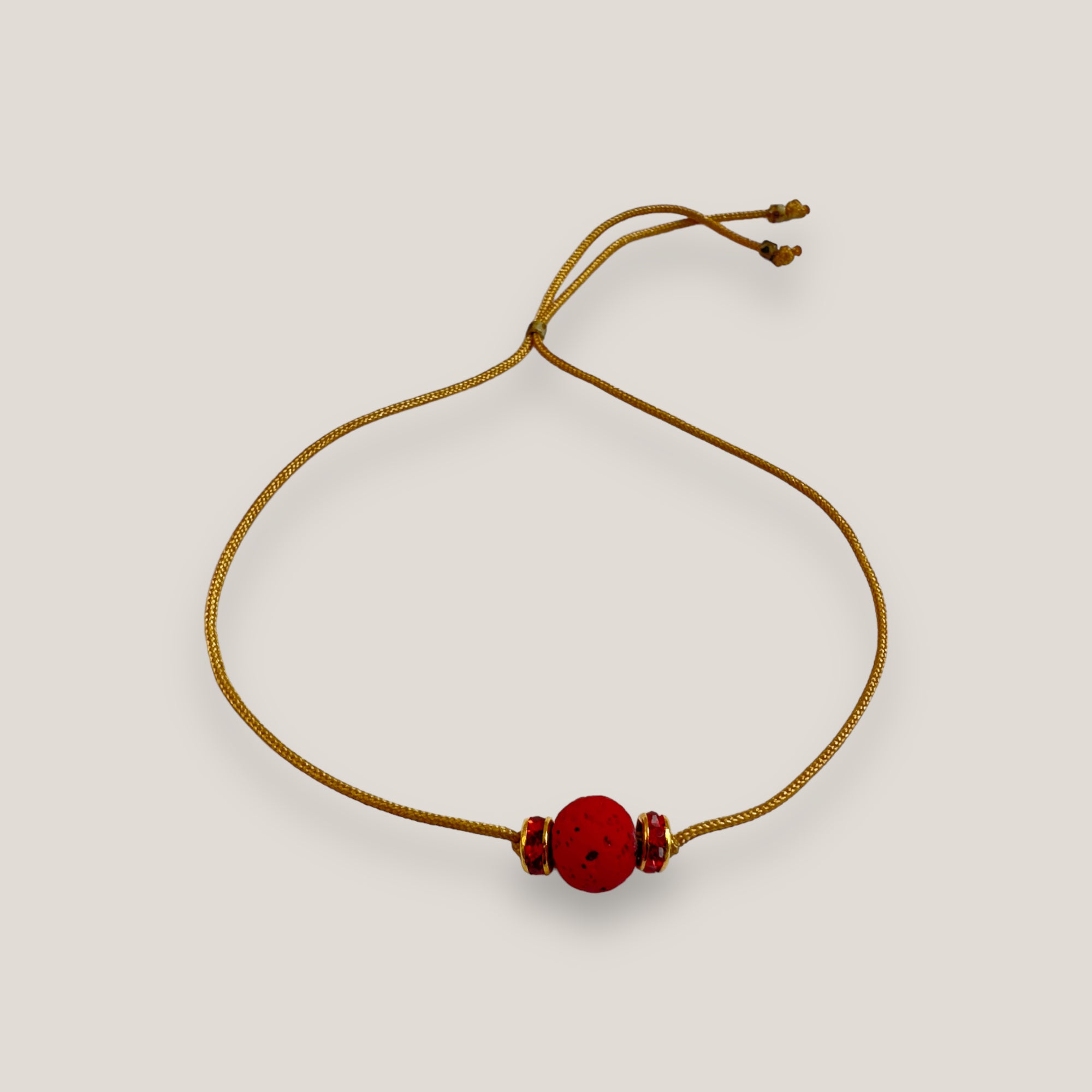 Pulsera minimal con bola de lava roja y cuentas doradas con brillis rojos