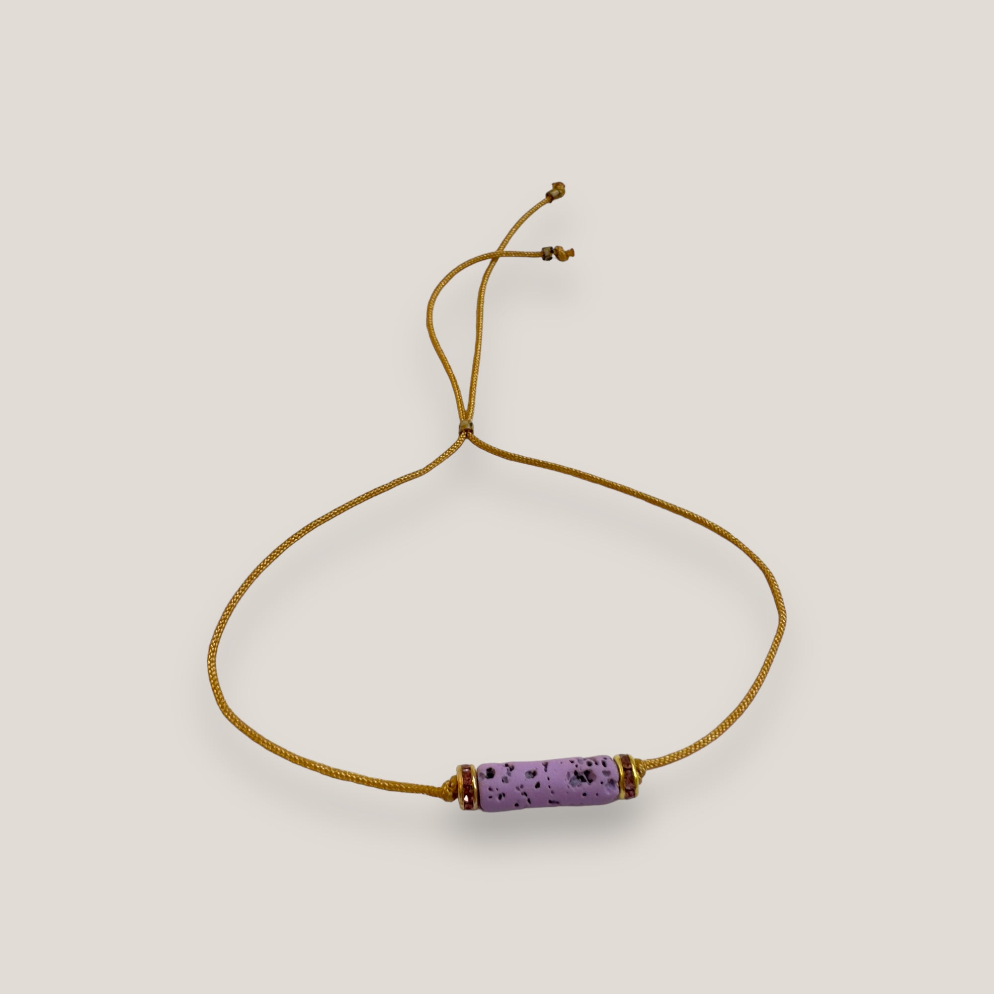 Pulsera minimal con tubo de lava malva y cuentas doradas con brillis rosas