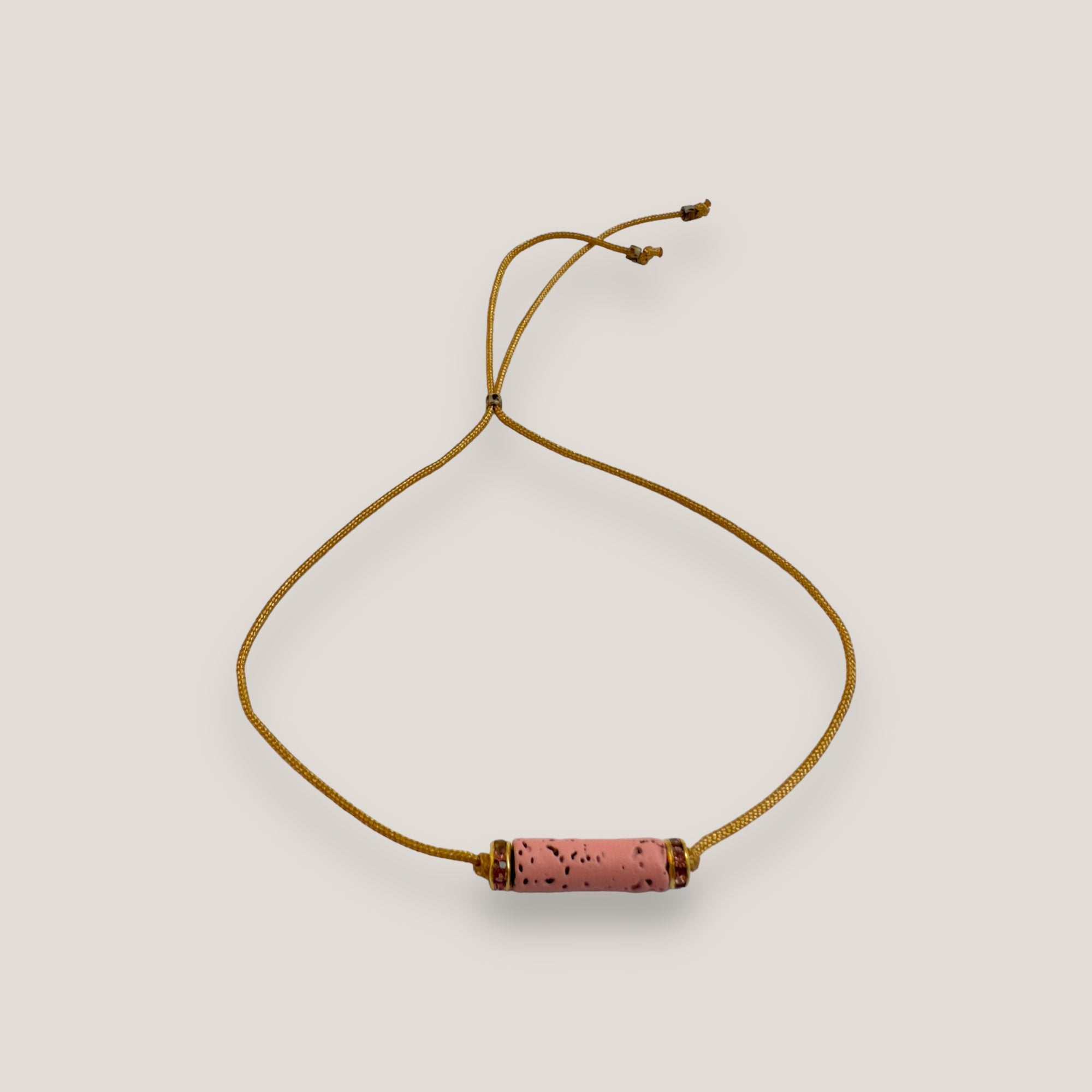 Pulsera minimal con tubo de lava rosa y cuentas doradas con brillis rosas