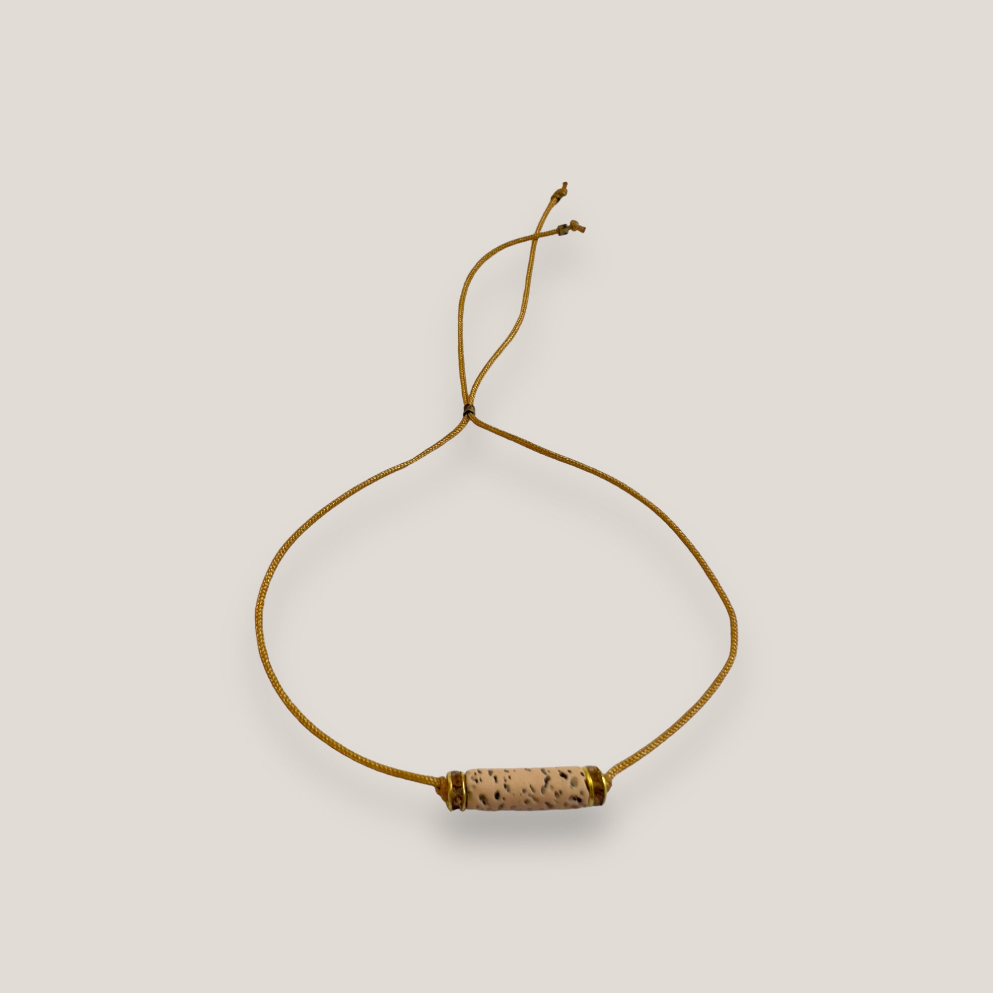 Pulsera minimal con tubo de lava arena y cuentas doradas con brillis ámbar