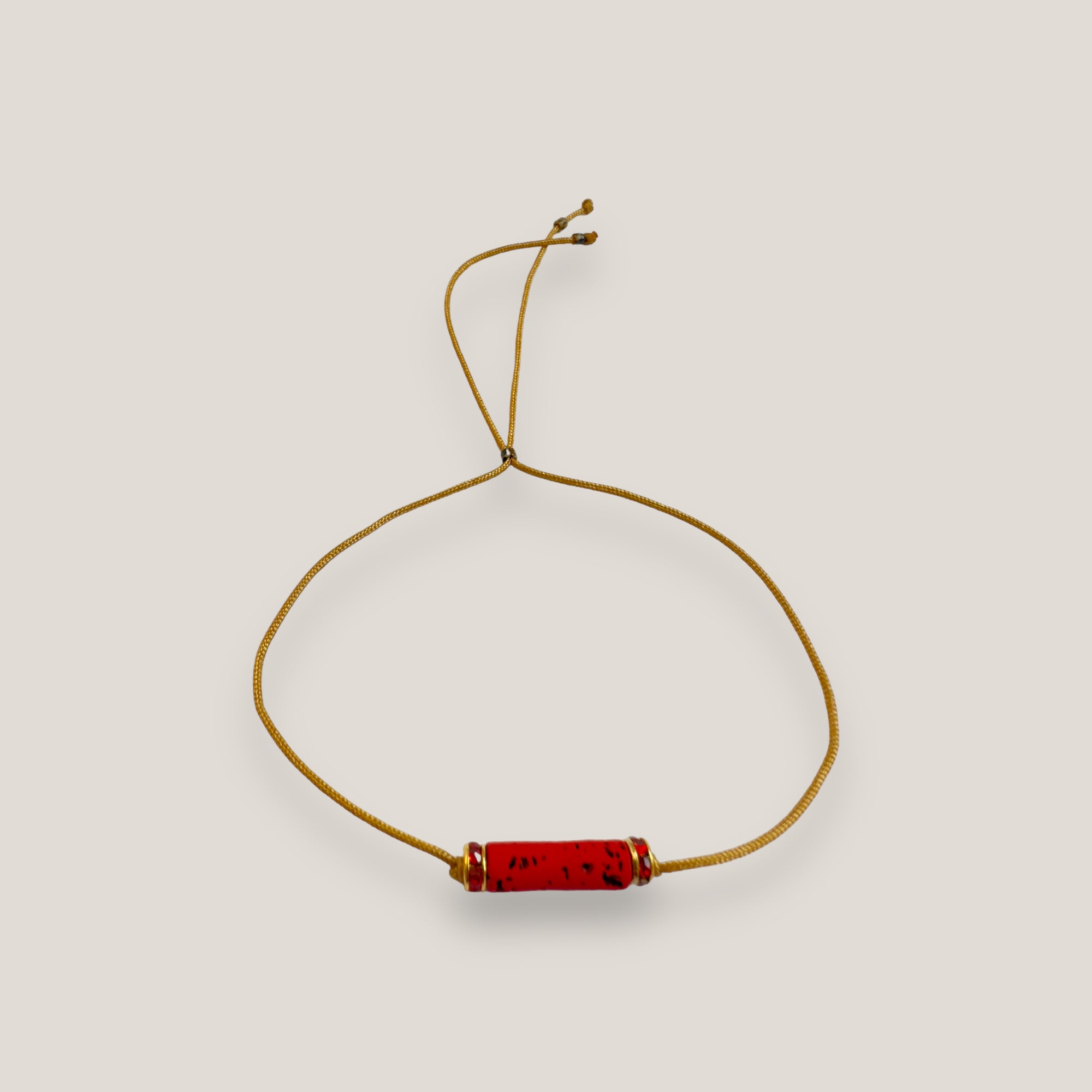Pulsera minimal con tubo de lava roja y cuentas doradas con brillis rojos