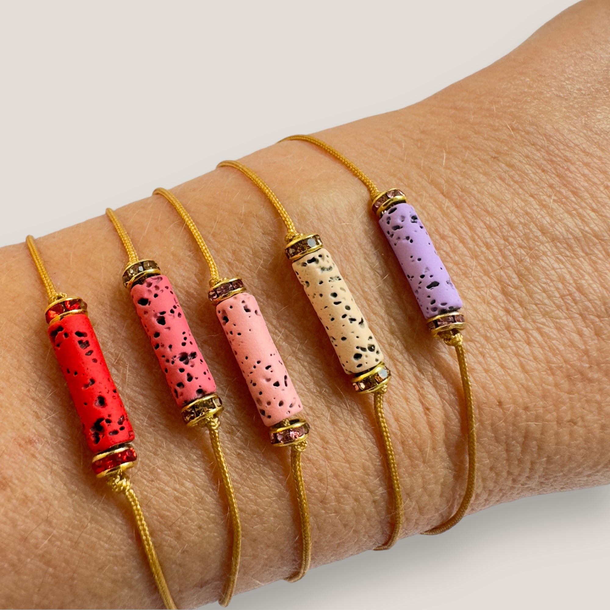 Pulsera minimal con tubo de lava roja y cuentas doradas con brillis rojos