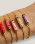 Pulsera minimal con tubo de lava roja y cuentas doradas con brillis rojos