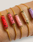 Minimales Armband mit lila Lavaröhre und goldenen Perlen mit rosa Glitzer