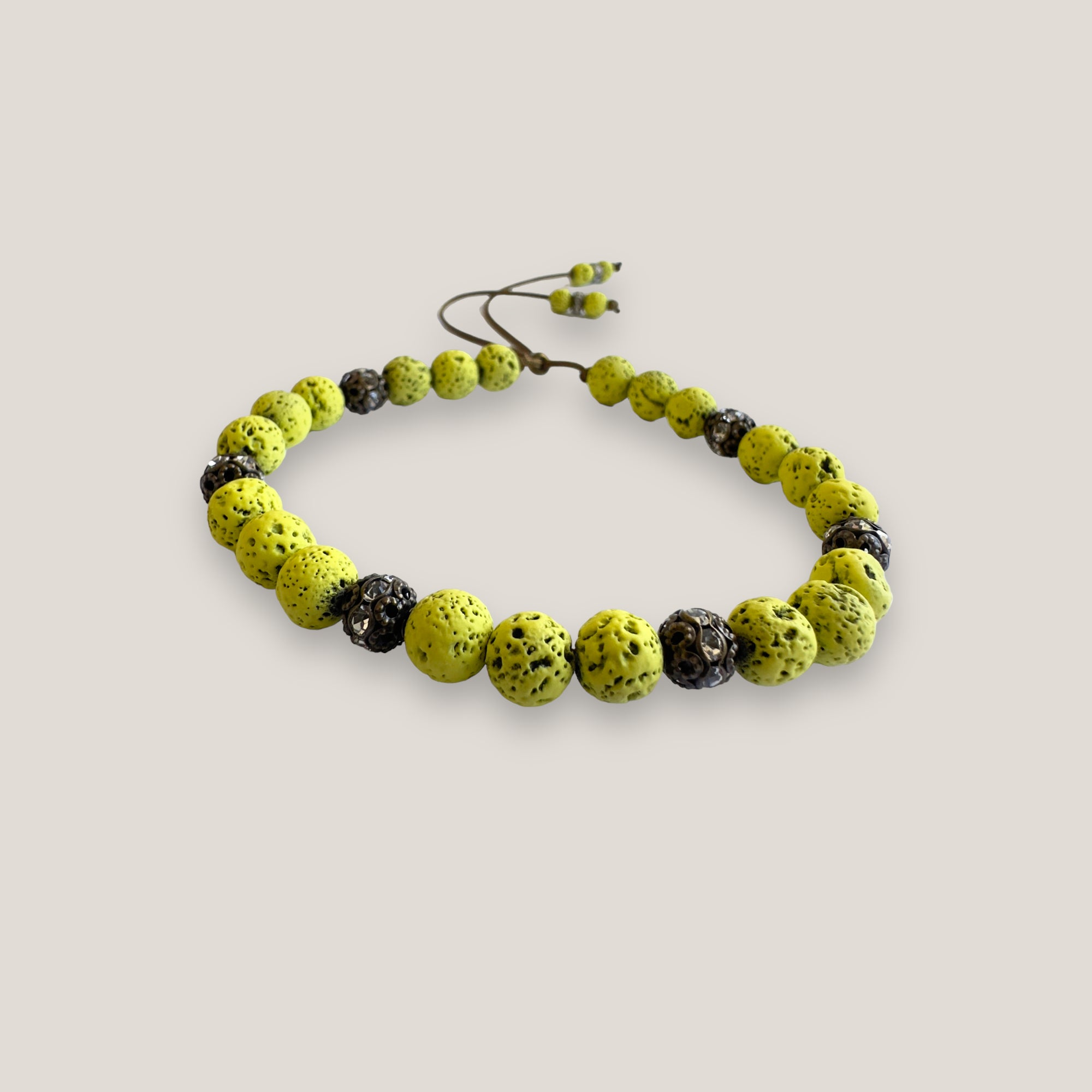 Pulsera Dafne con lava verde claro y filigrana bronce con cristalitos