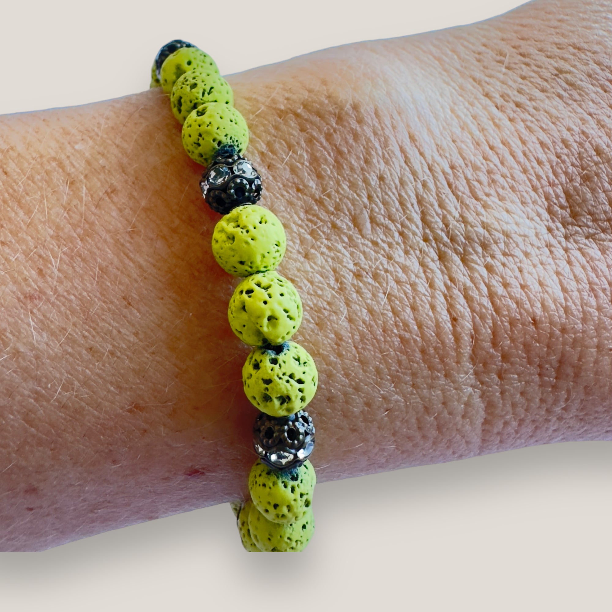 Pulsera Dafne con lava verde claro y filigrana bronce con cristalitos