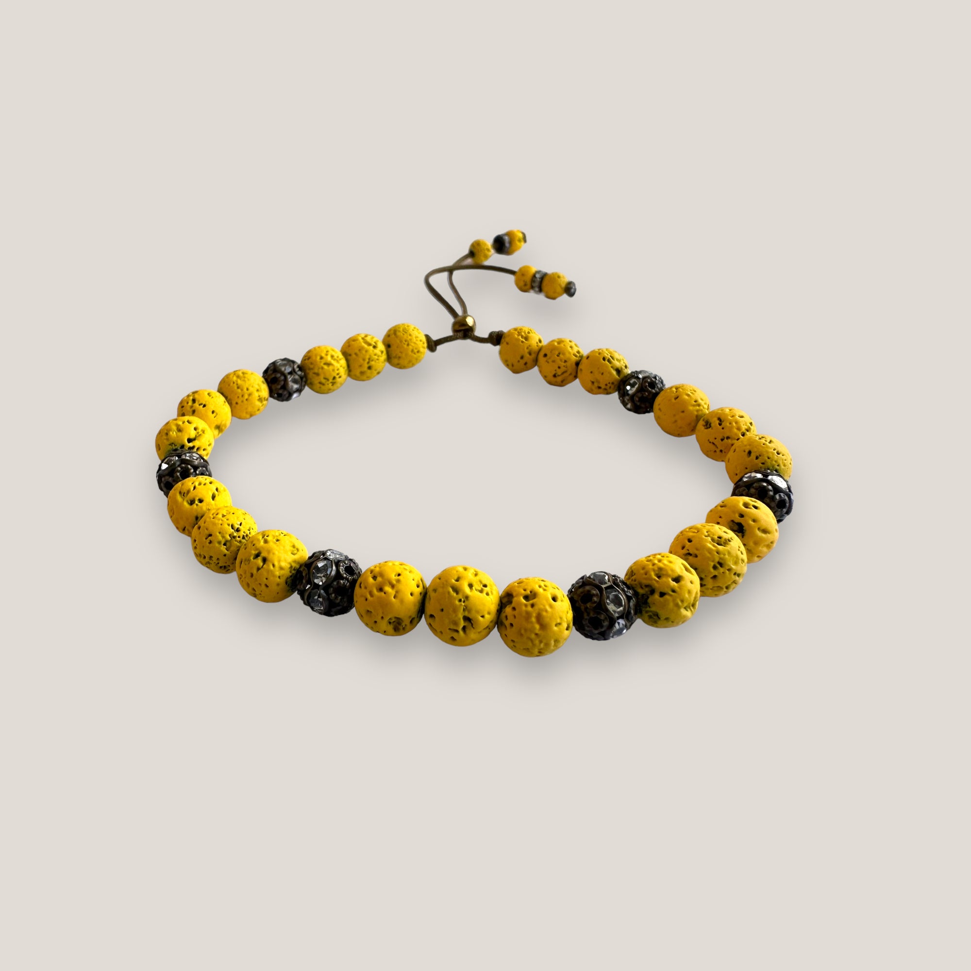 Pulsera Dafne con lava amarillo fuerte y filigrana bronce con cristalitos