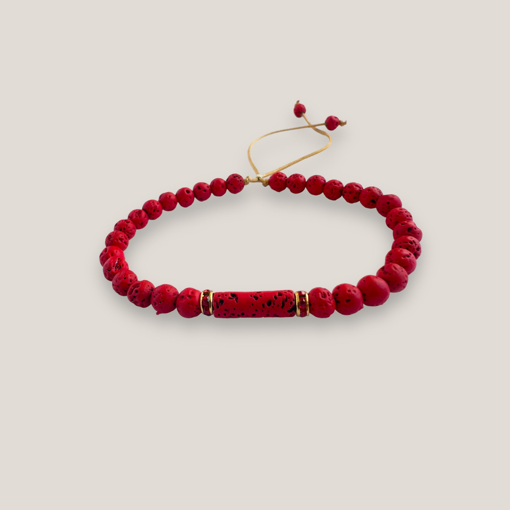 Pulsera con tubo, cuentas de lava roja y brillis oro con cristalitos rojos