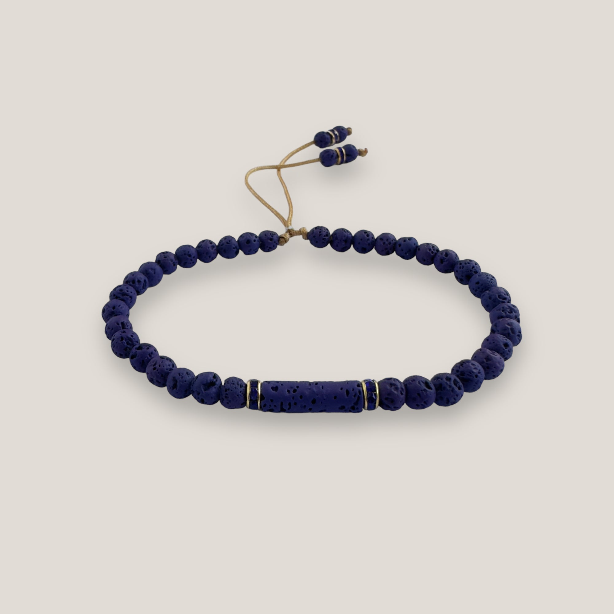 Pulsera con tubo, cuentas de lava azul profundo y brillis oro con cristalitos azules