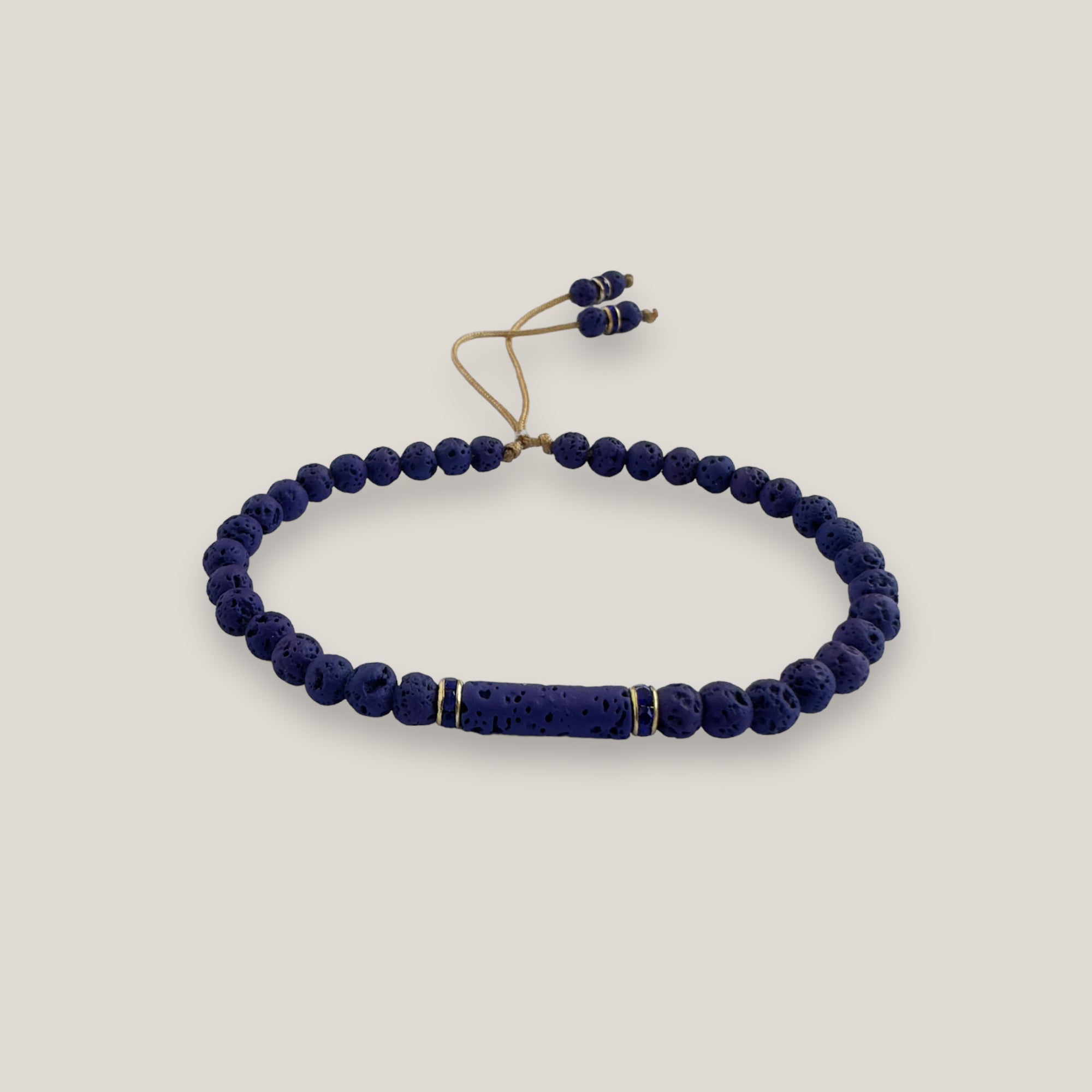 Pulsera con tubo, cuentas de lava azul profundo y brillis oro con cristalitos azules