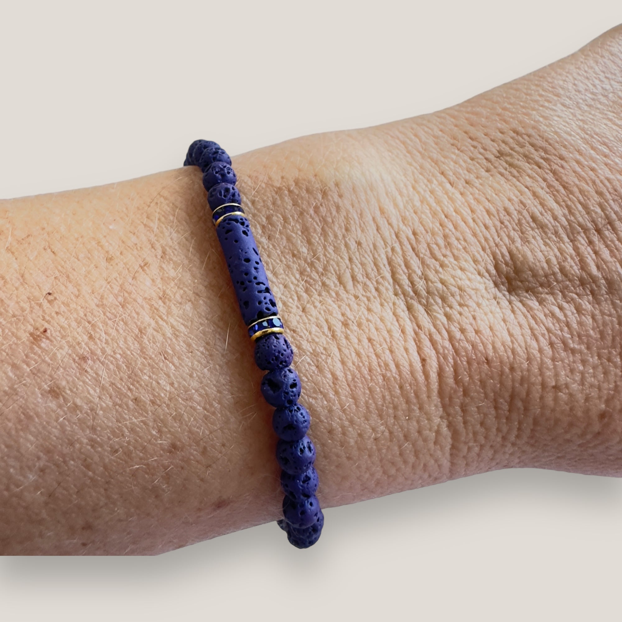 Pulsera con tubo, cuentas de lava azul profundo y brillis oro con cristalitos azules