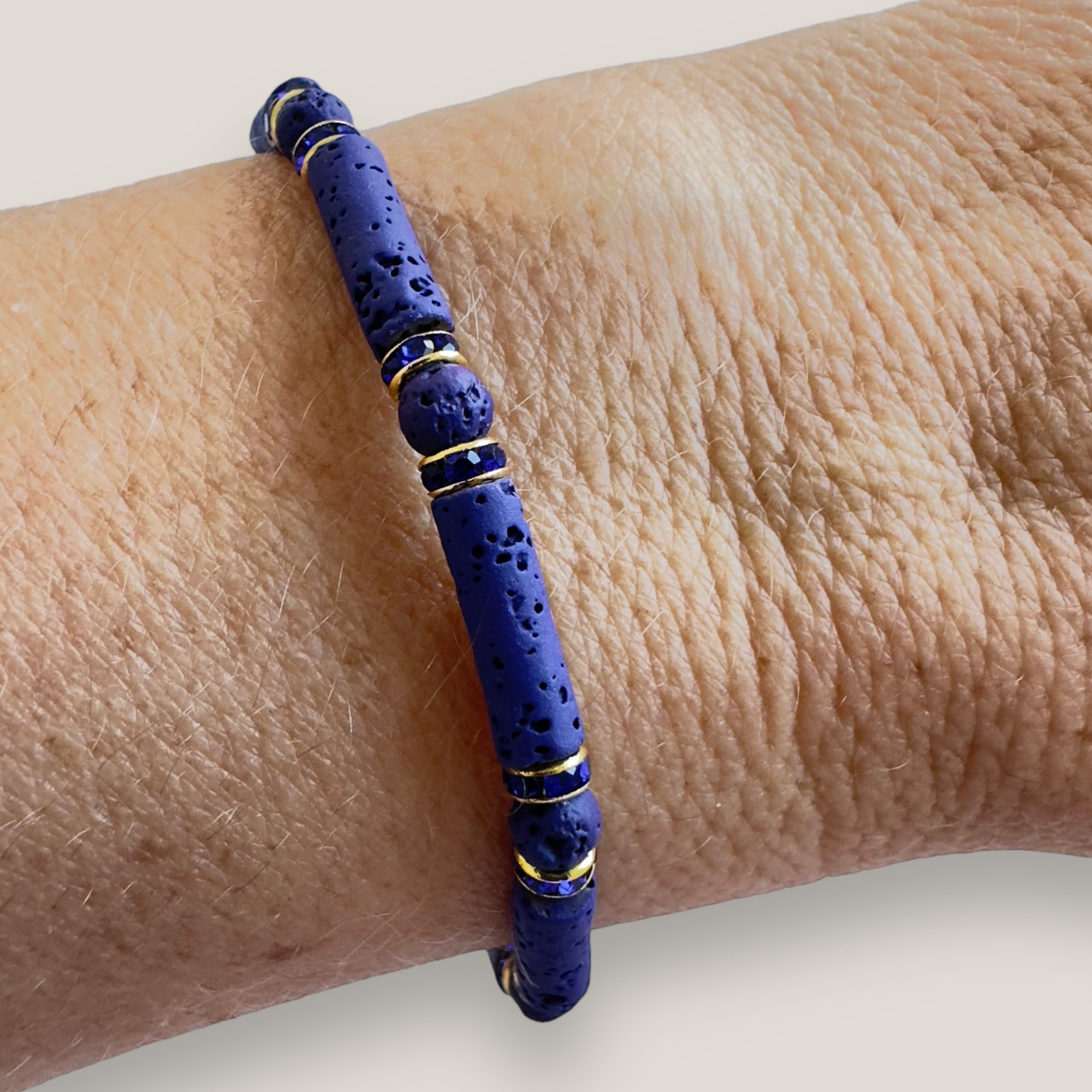Pulsera con tubos y cuentas de lava azul profundoy brillis oro con cristalitos azules