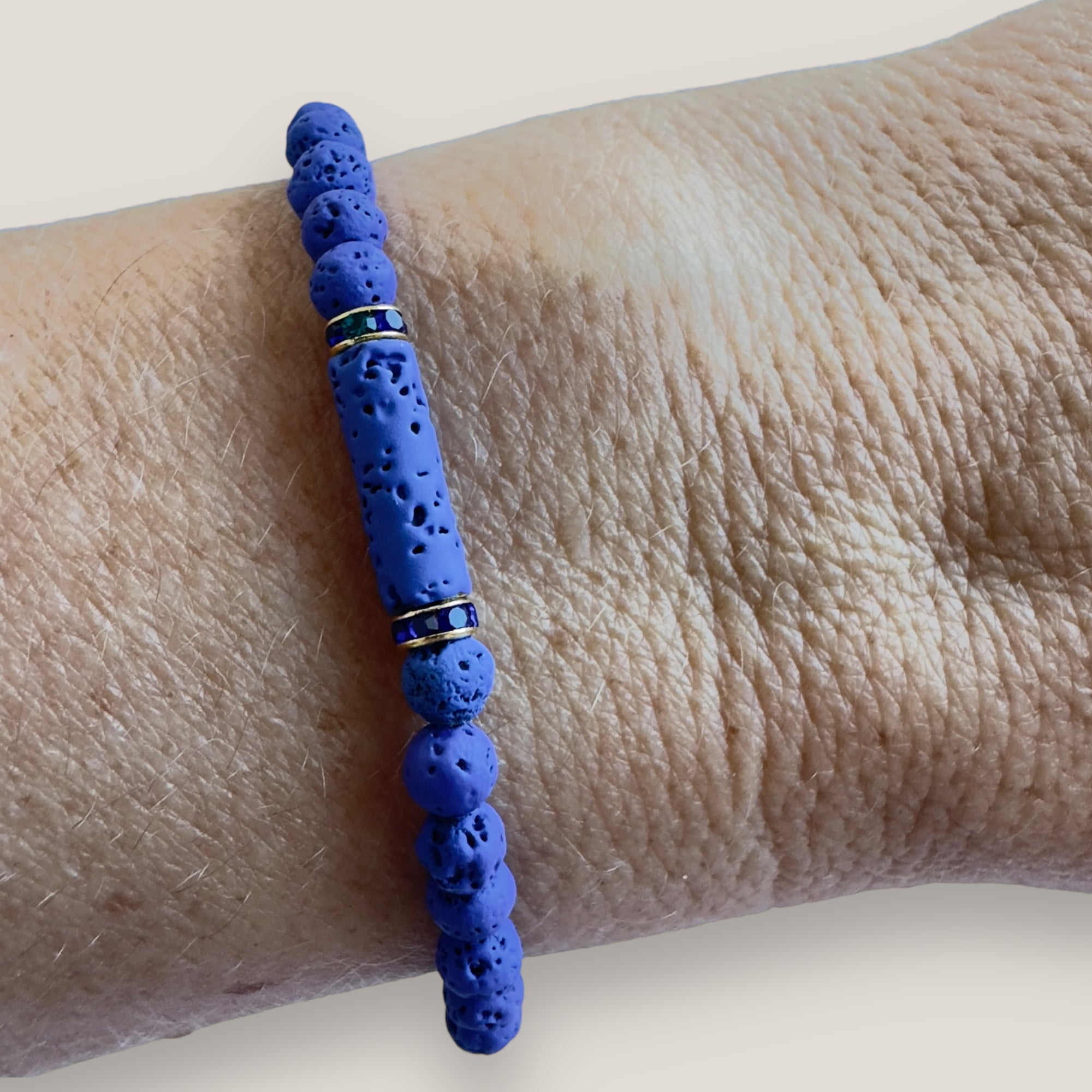 Pulsera con tubo, cuentas de lava en azulón y brillis oro con cristalitos azules