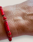 Pulsera con tubos y cuentas de lava roja y brillis oro con cristalitos rojos