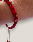 Pulsera con tubos y cuentas de lava roja y brillis oro con cristalitos rojos