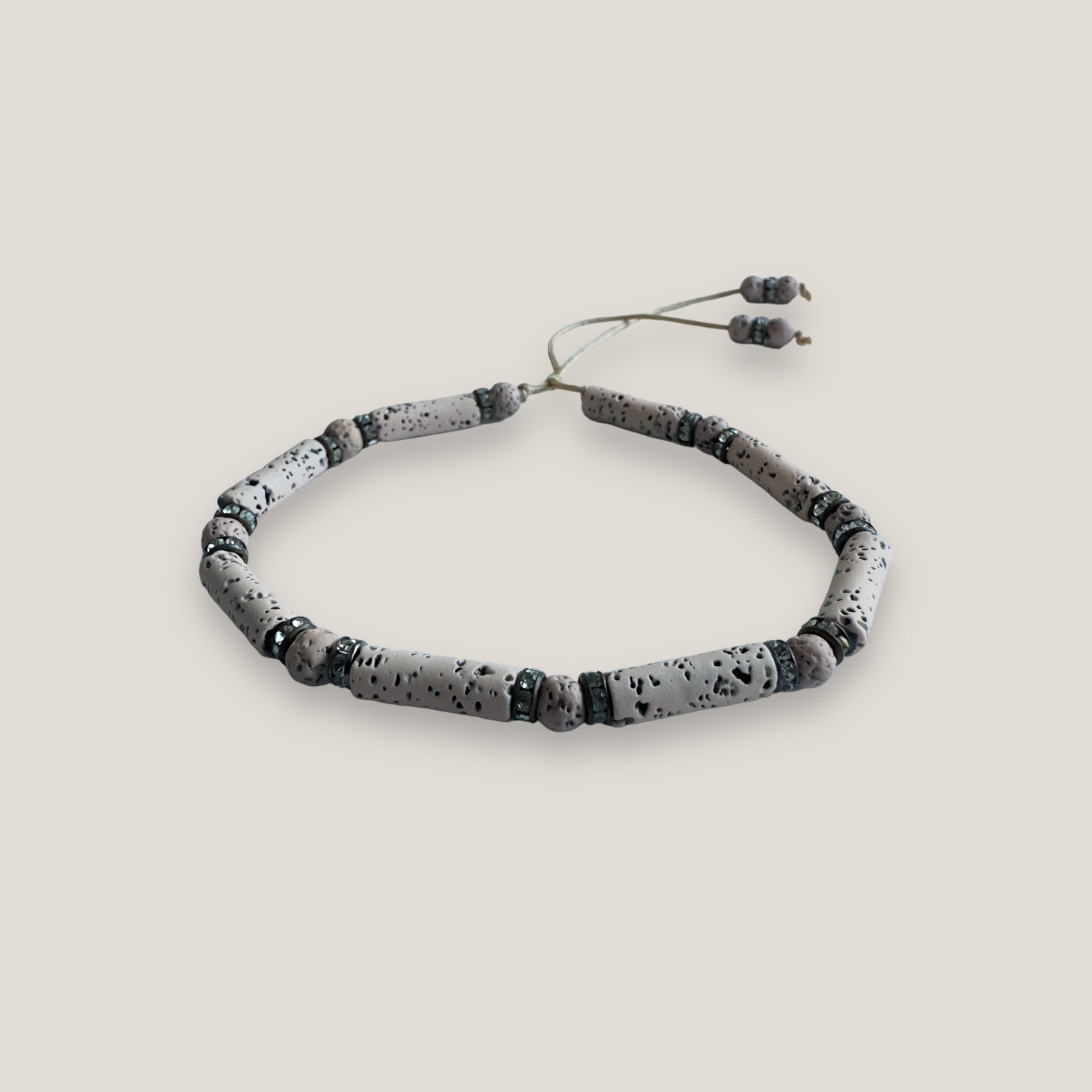Pulsera con tubo, cuentas de lava arena y brillis broce con cristalitos blancos