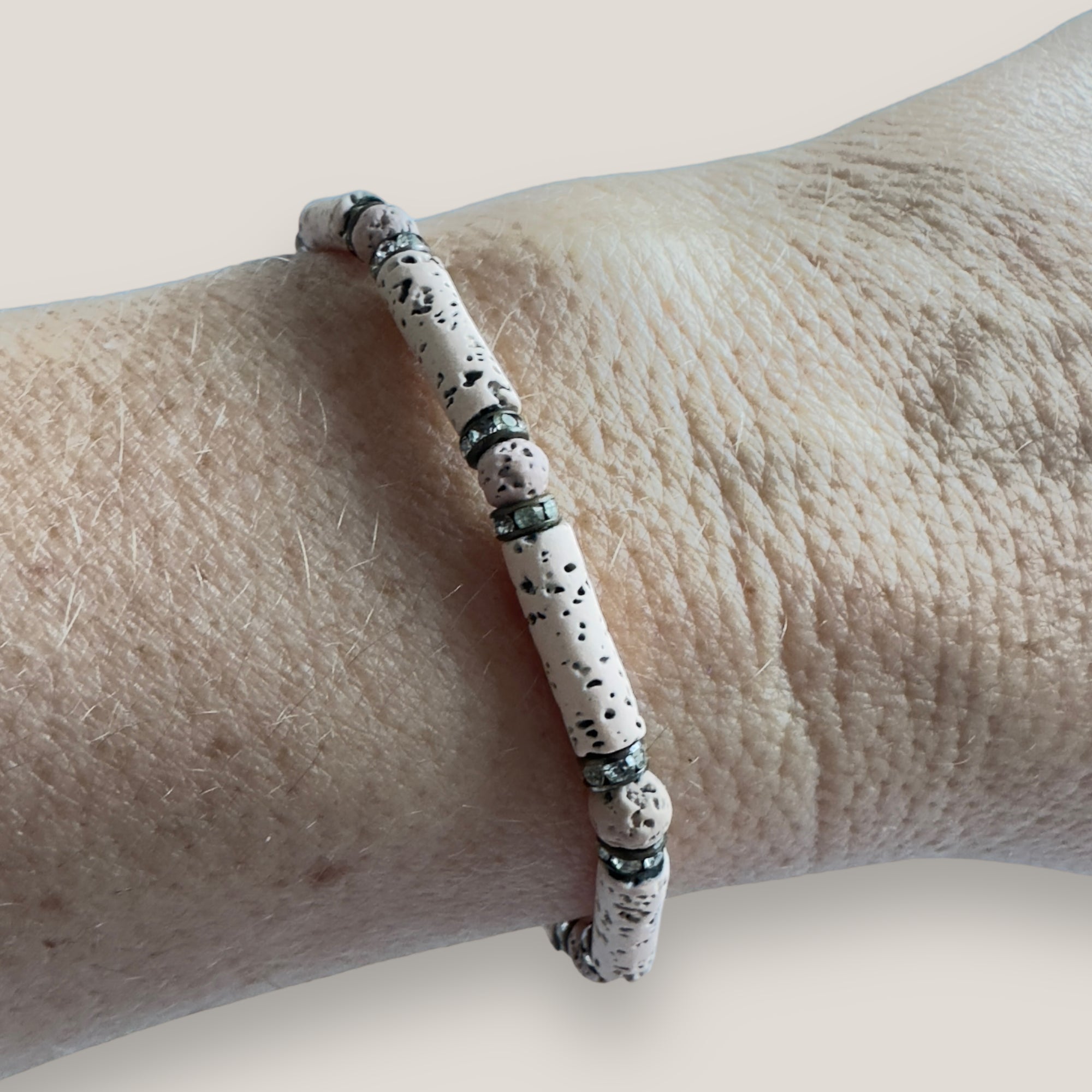 Pulsera con tubo, cuentas de lava arena y brillis broce con cristalitos blancos