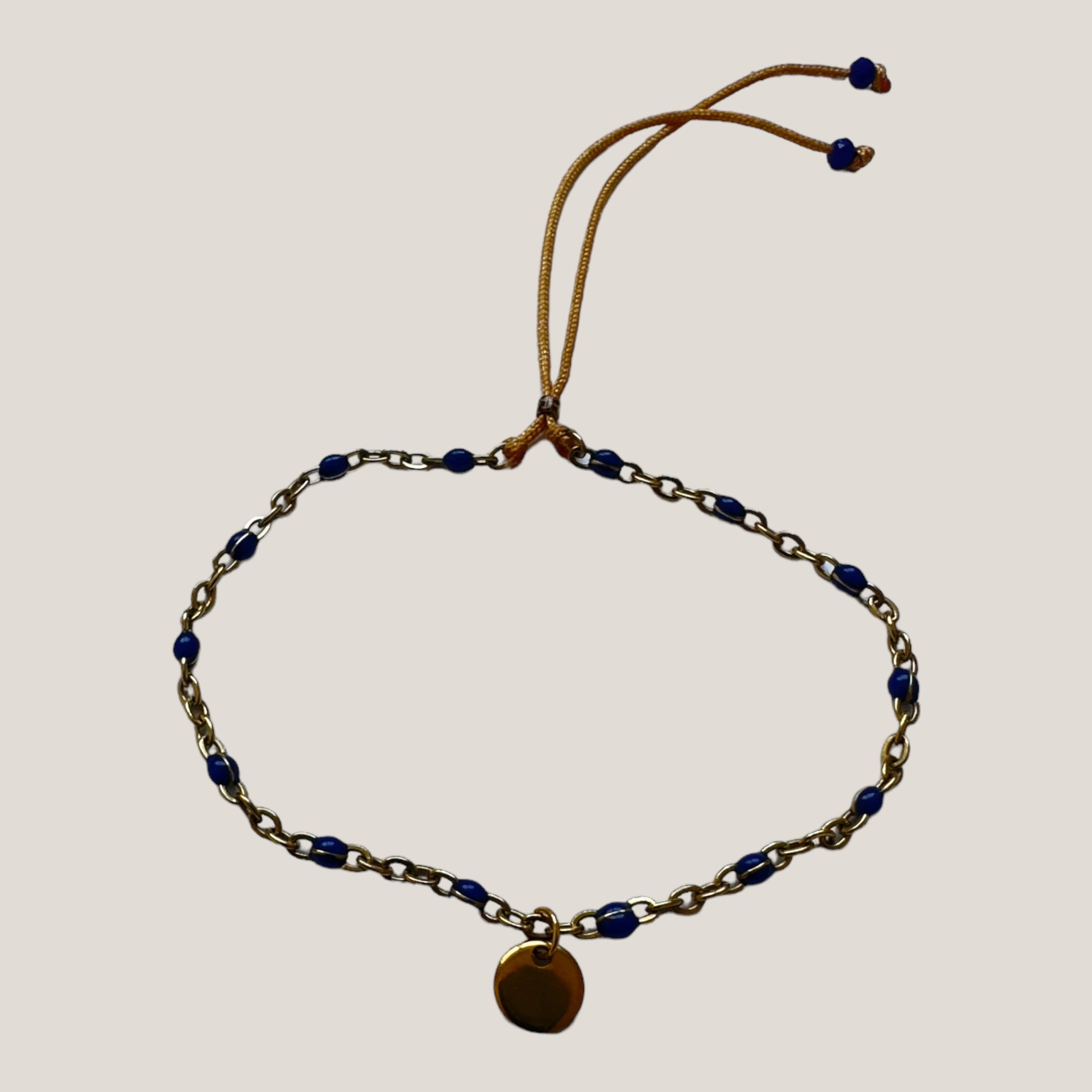 Goldene Stahlkette und Medaillonarmband mit marineblauen Emaille-Kugeln