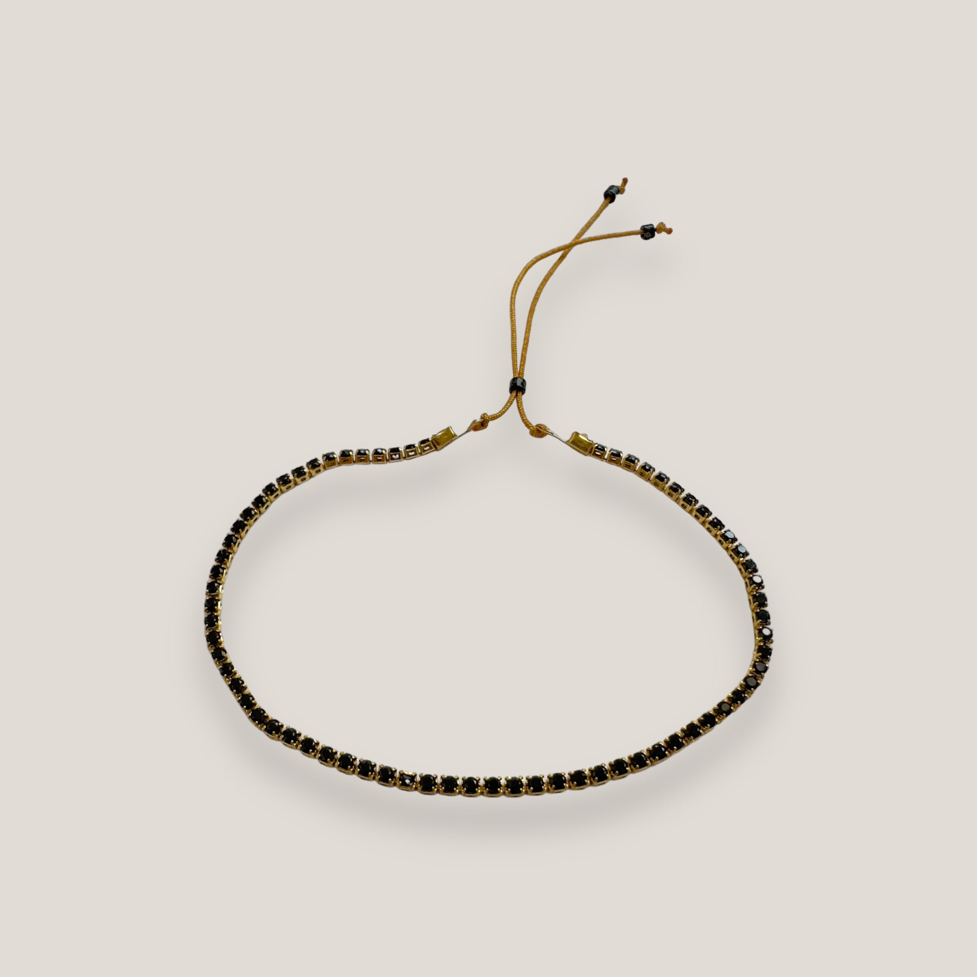 Pulsera tenis de acero oro con cristalitos de 2mm negros