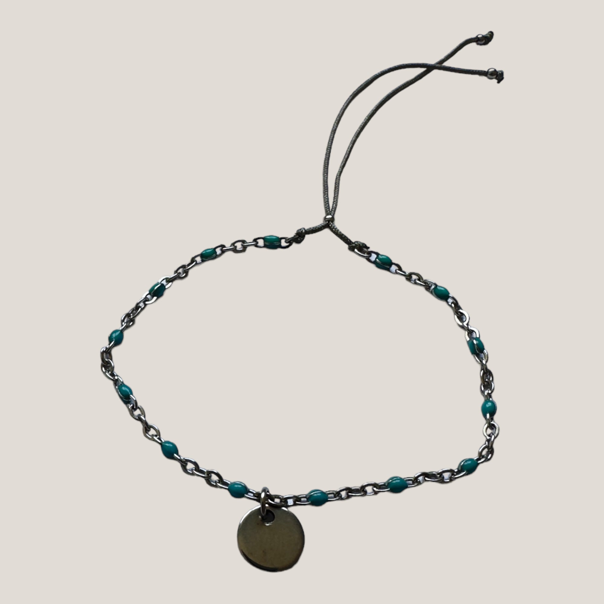 Kettenarmband und Stahlmedaille mit türkis emaillierten Kugeln