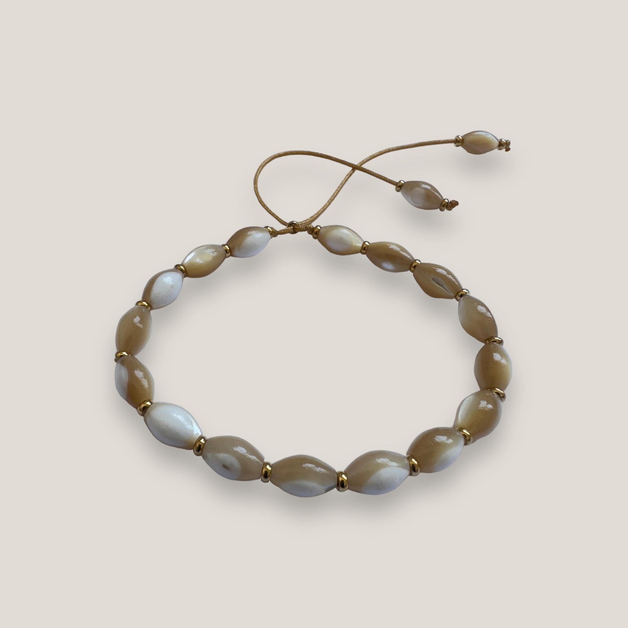 Armband aus beigem Perlmuttfässern 8x6 mm und goldenen Stahlperlen