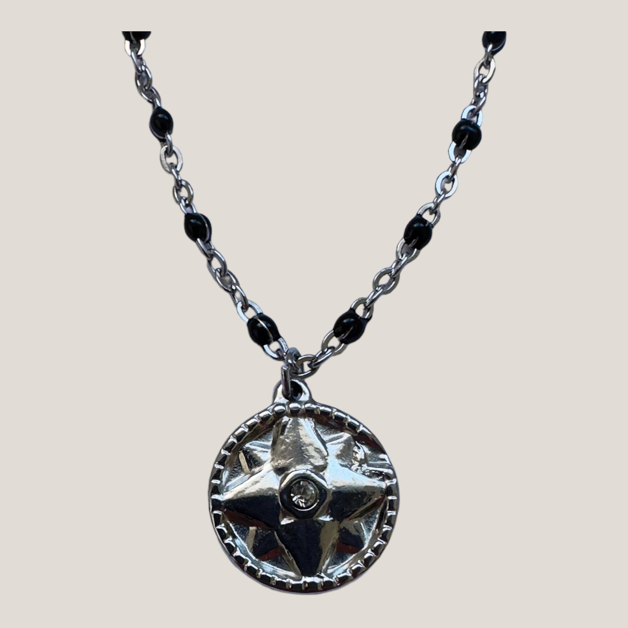 Collar cadena de acero con bolitas esmaltadas en negro y medalla rosa de los vientos con circonita