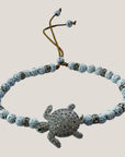 Pulsera con tortuga brillis plateada con lava blanca y más brillis