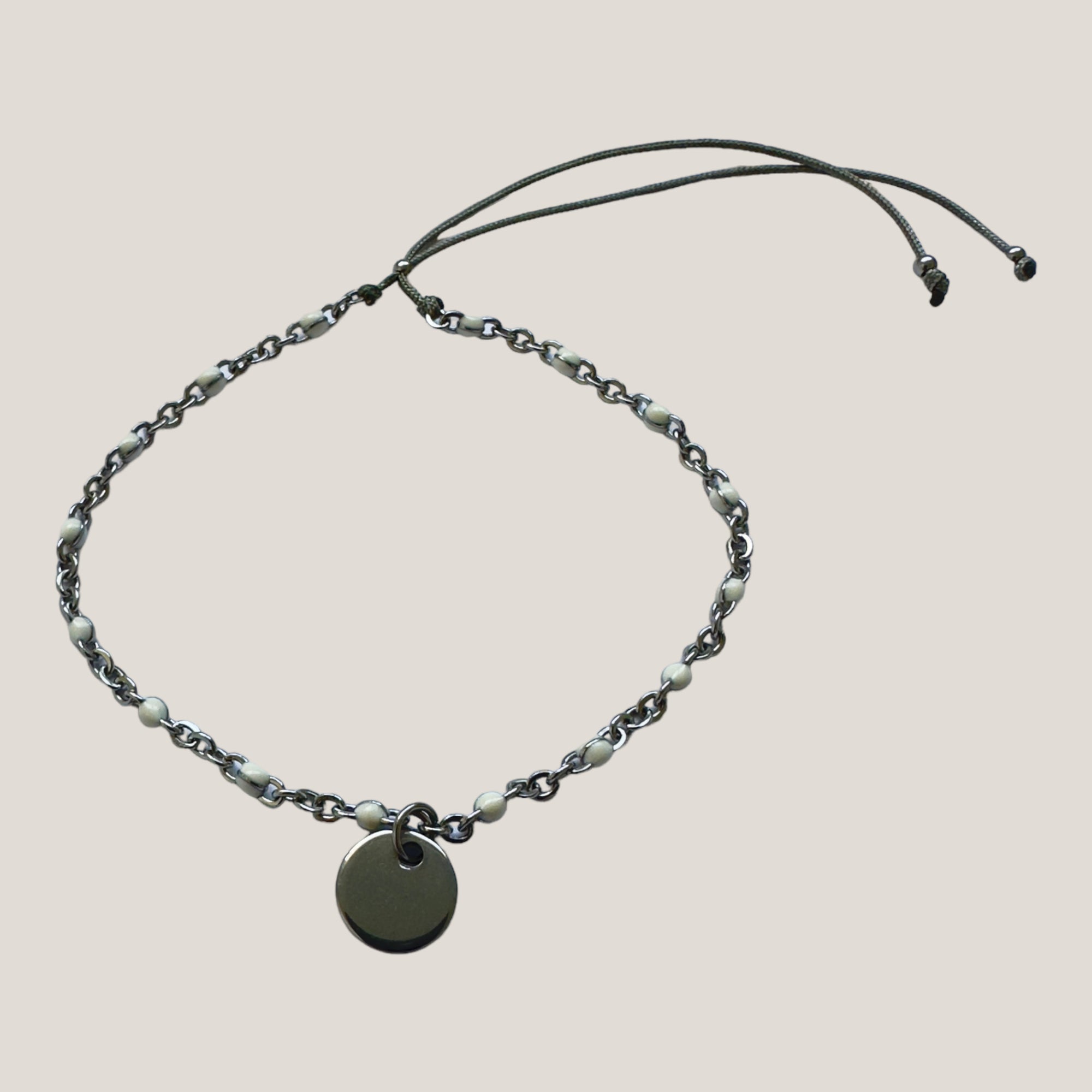 Kettenarmband und Stahlmedaille mit weiß emaillierten Kugeln