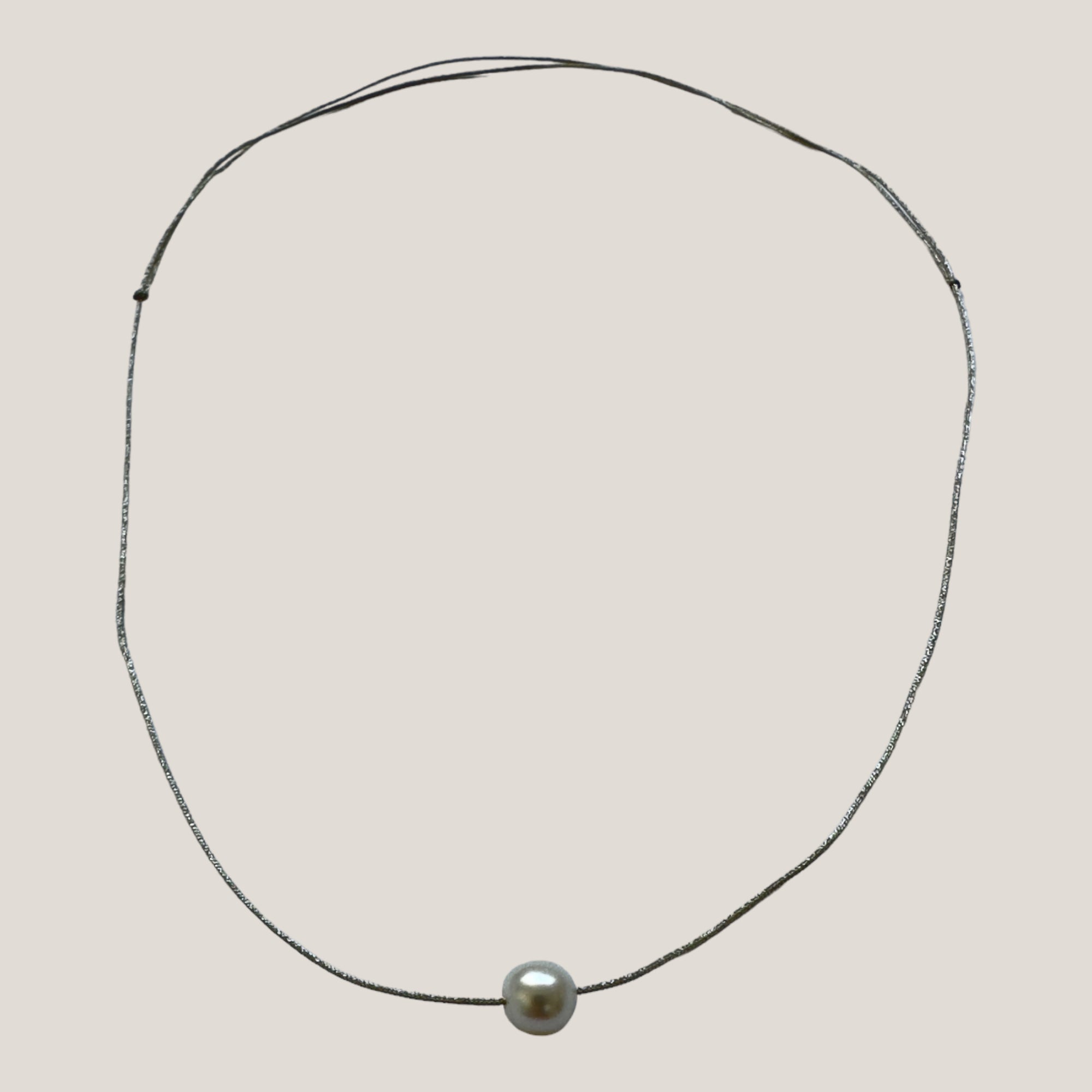 Collar minimal con perla natural, cordón plata y nudos correderos
