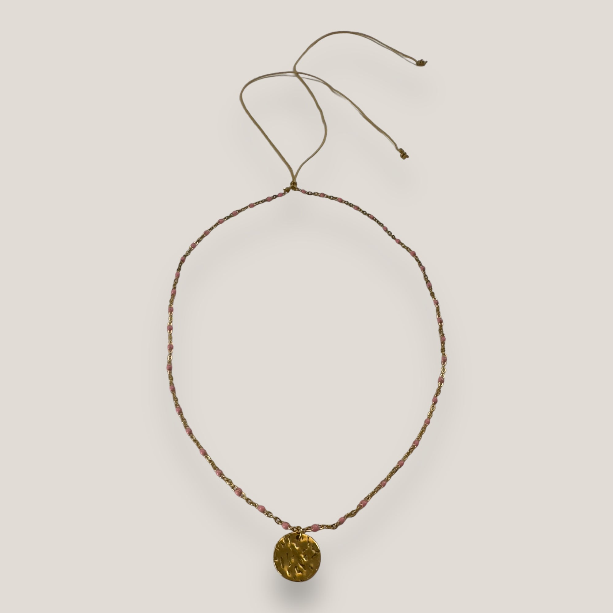Goldene Stahlkette mit rosa Emaille-Kugeln und gehämmerter Medaille