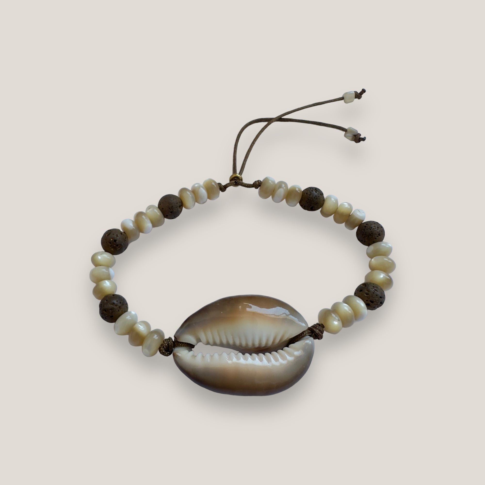 Armband mit brauner Kaurimuschel, beigen Perlmuttscheiben und bronzierten Lavaperlen
