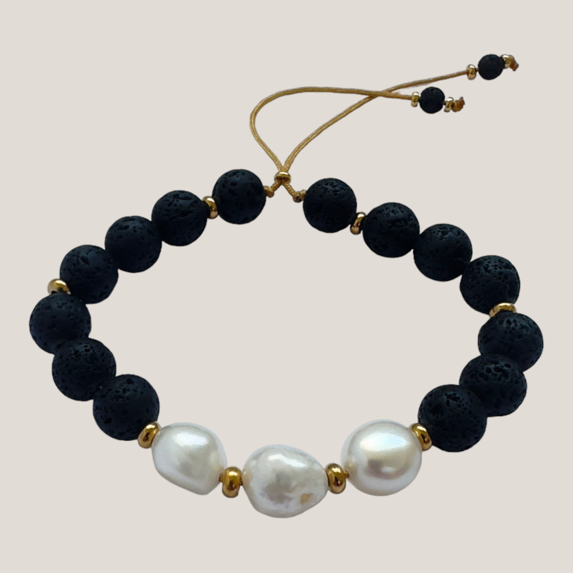 Pulsera con tres perlas naturales, lava negra y cuentas de acero