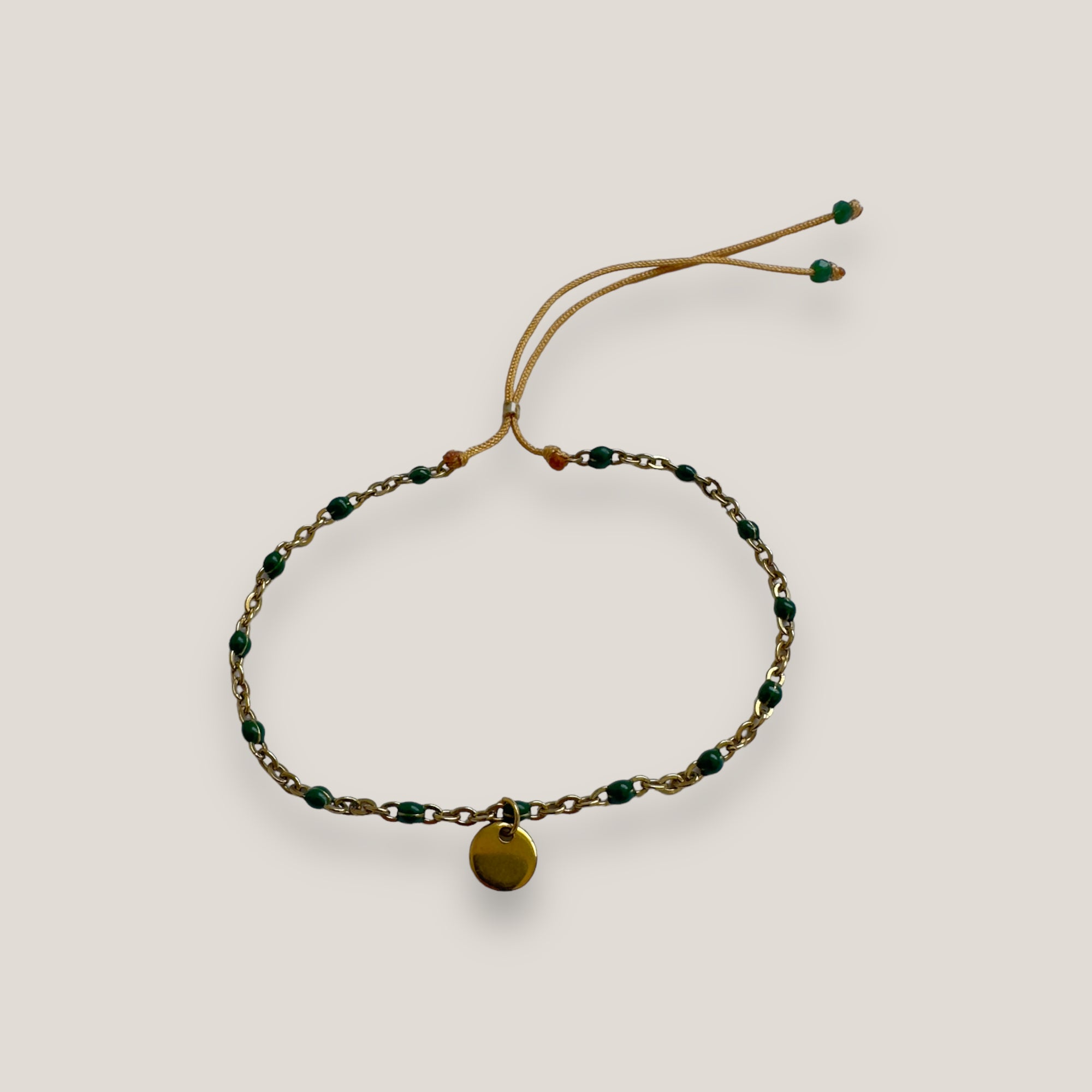 Kettenarmband und goldene Stahlmedaille mit dunkelgrün emaillierten Kugeln