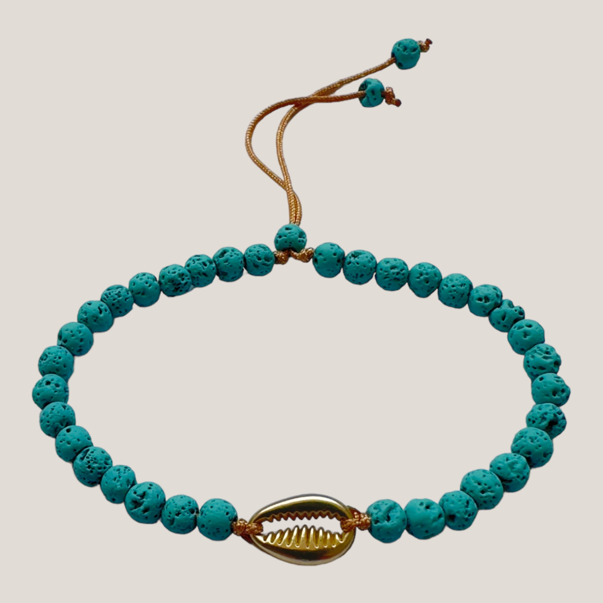 Armband mit goldener Kauri und türkisfarbener Lava
