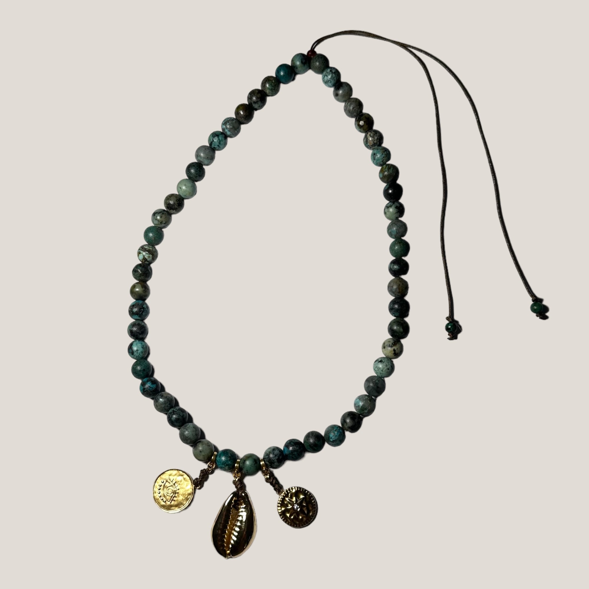 African turquoise necklace with gold cowrie and charms wind rose and lucky eye gold steel