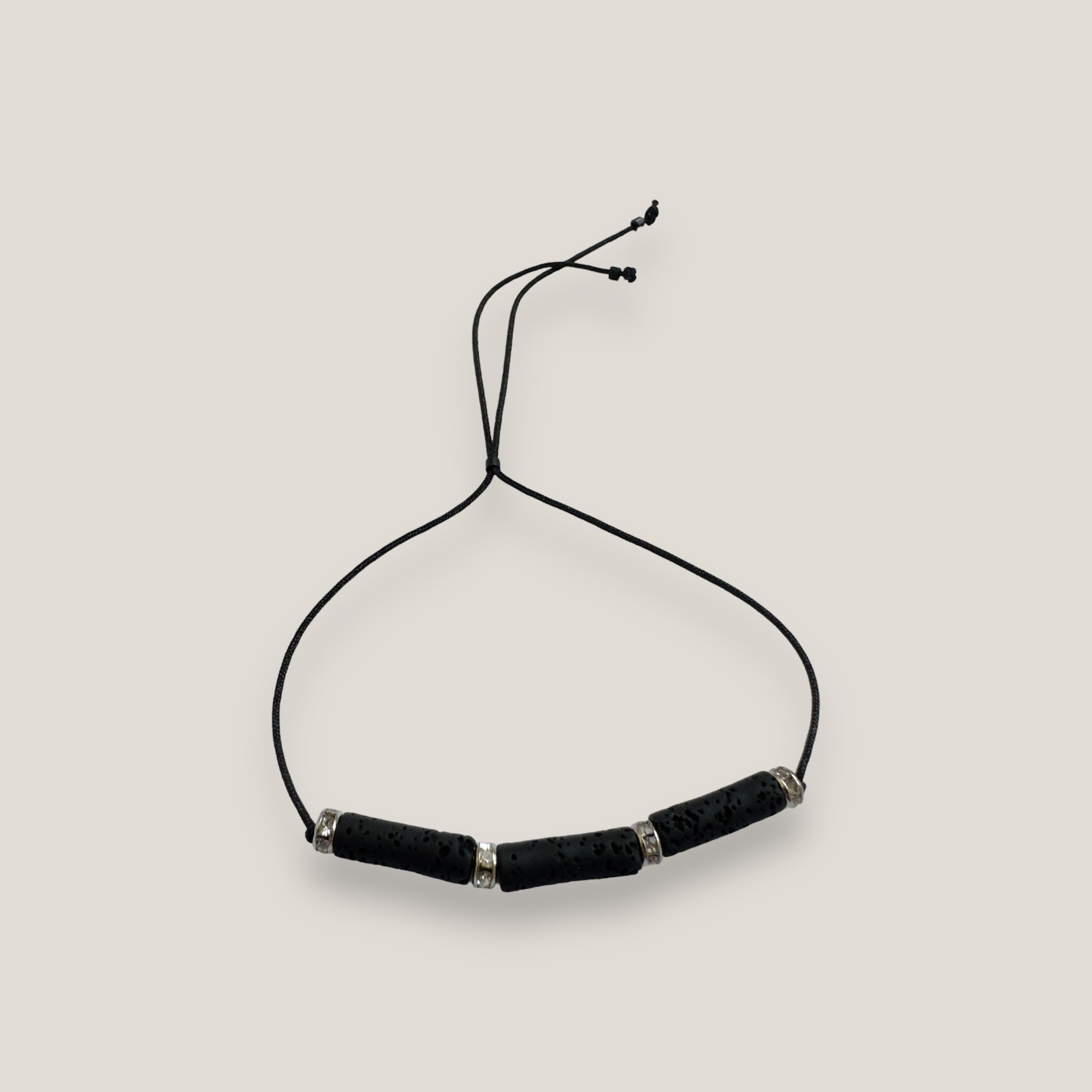 Pulsera minimal con tres tubos de lava negra y brillis plata con cristalitos blancos