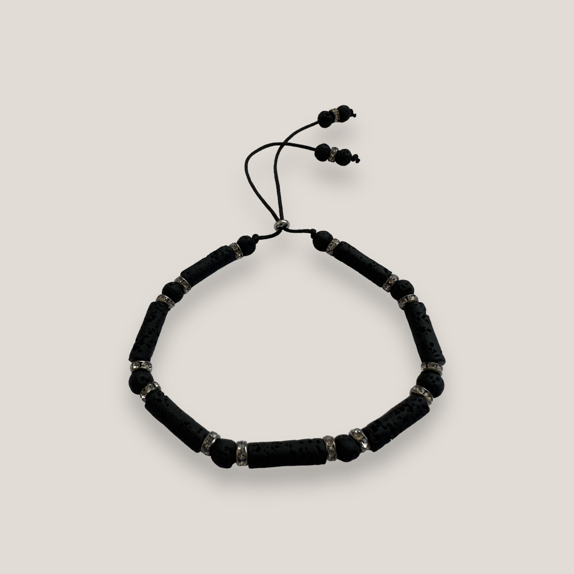 Pulsera con tubos y cuentas de lava negra y brillis gunmetal con cristalitos blancos