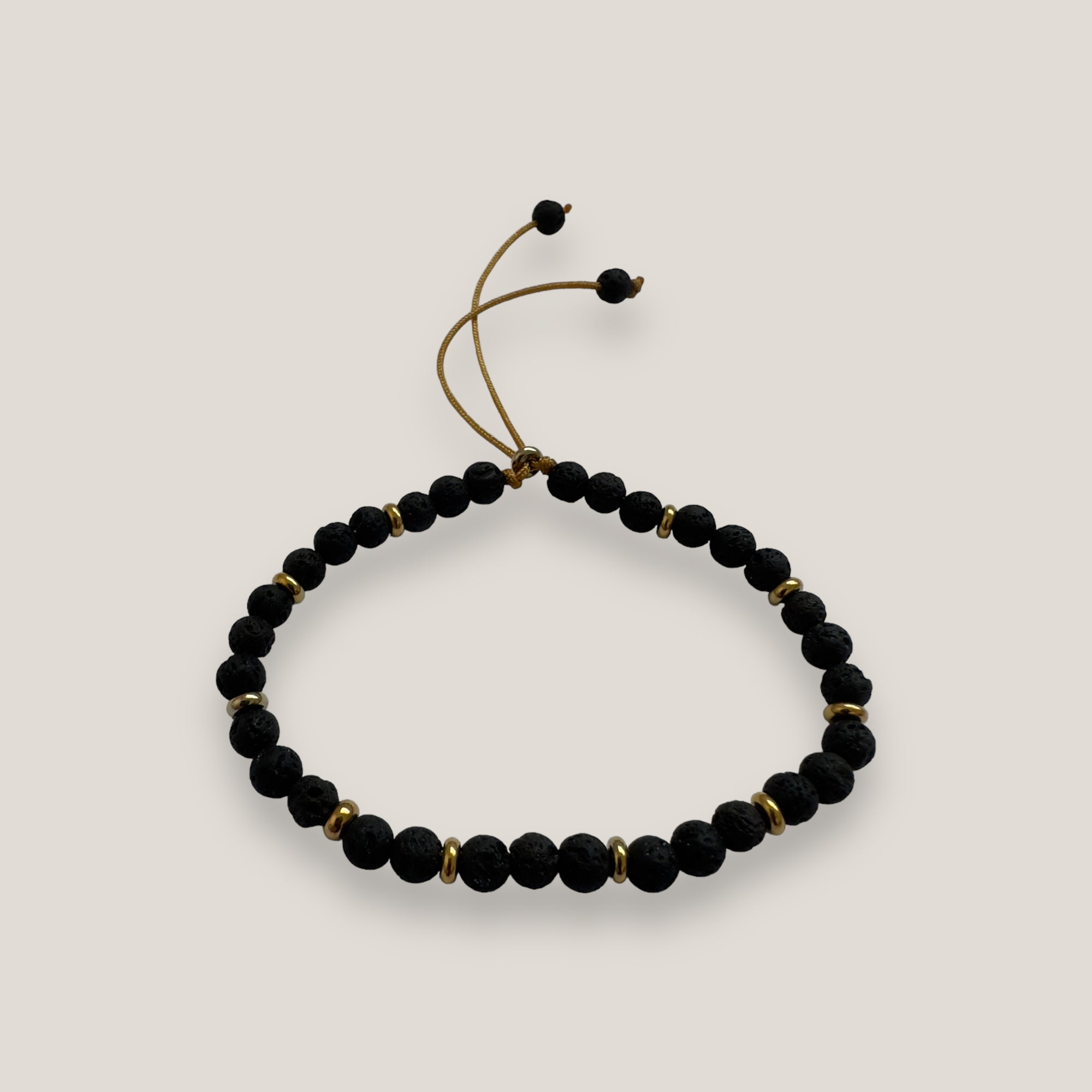 Armband mit goldenen Stahlringperlen und schwarzer Lava