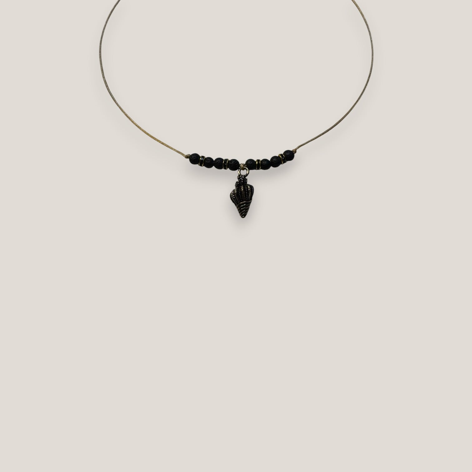 Collar midi con caracola dorada esmaltada en negro lava negra y separadores dorados con cristalitos negros