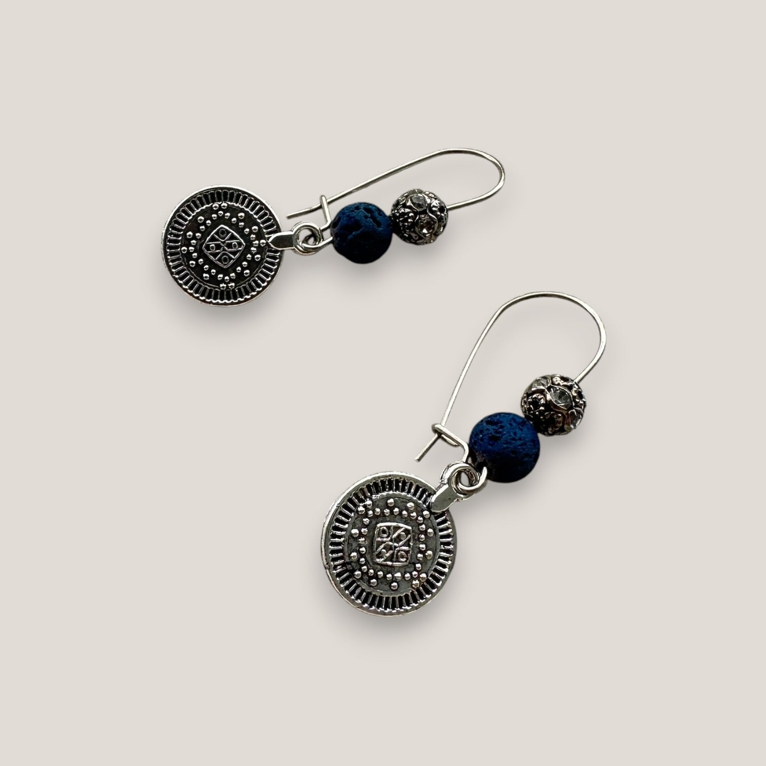 Pendientes Dafne gancho con medalla tribal pequeña de plata vieja lava azul añil y filigrana gunmetal con cristales blancos