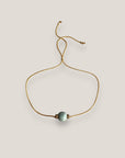 Minimalistisches Armband mit einer 8 mm großen türkisfarbenen Schwammkorallenkugel und goldenen Trennelementen mit funkelnden weißen Kristallen.