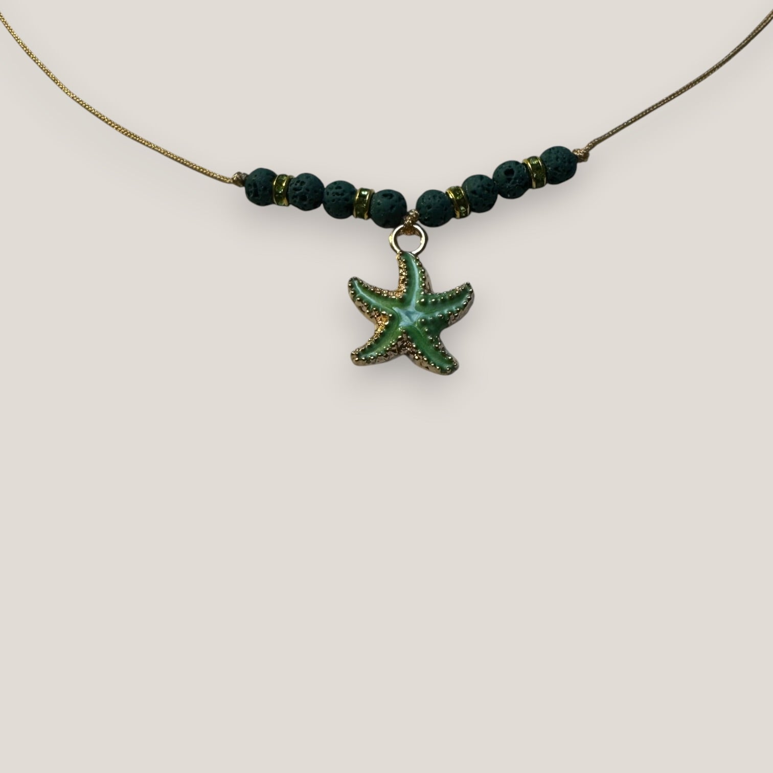 Collar midi con estrella dorada esmaltada en verde con lava verde oscuro y separadores dorados con cristalitos verde olivina