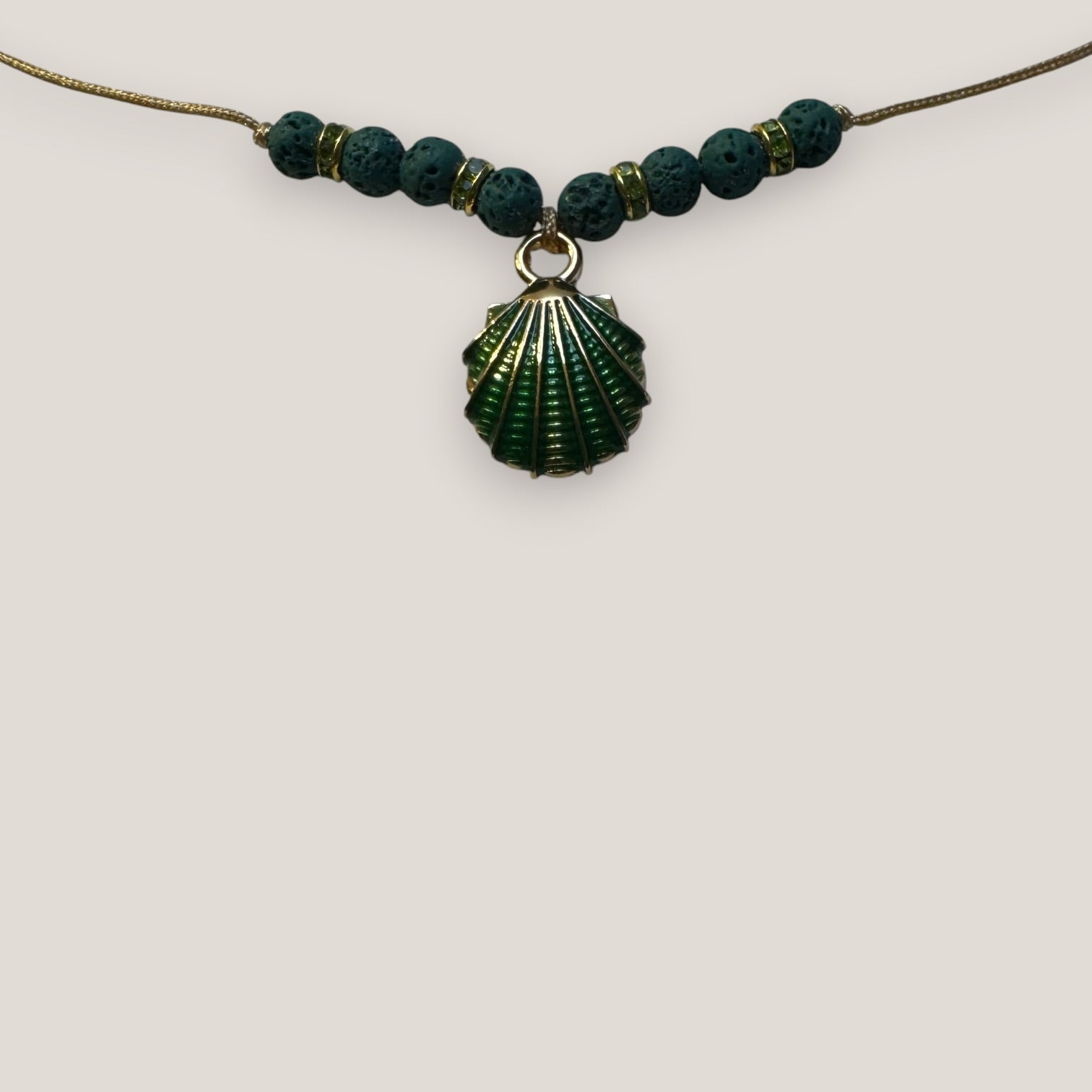 Collar midi con concha dorada esmaltada en verde con lava verde oscuro y separadores dorados con cristalitos verde olivina