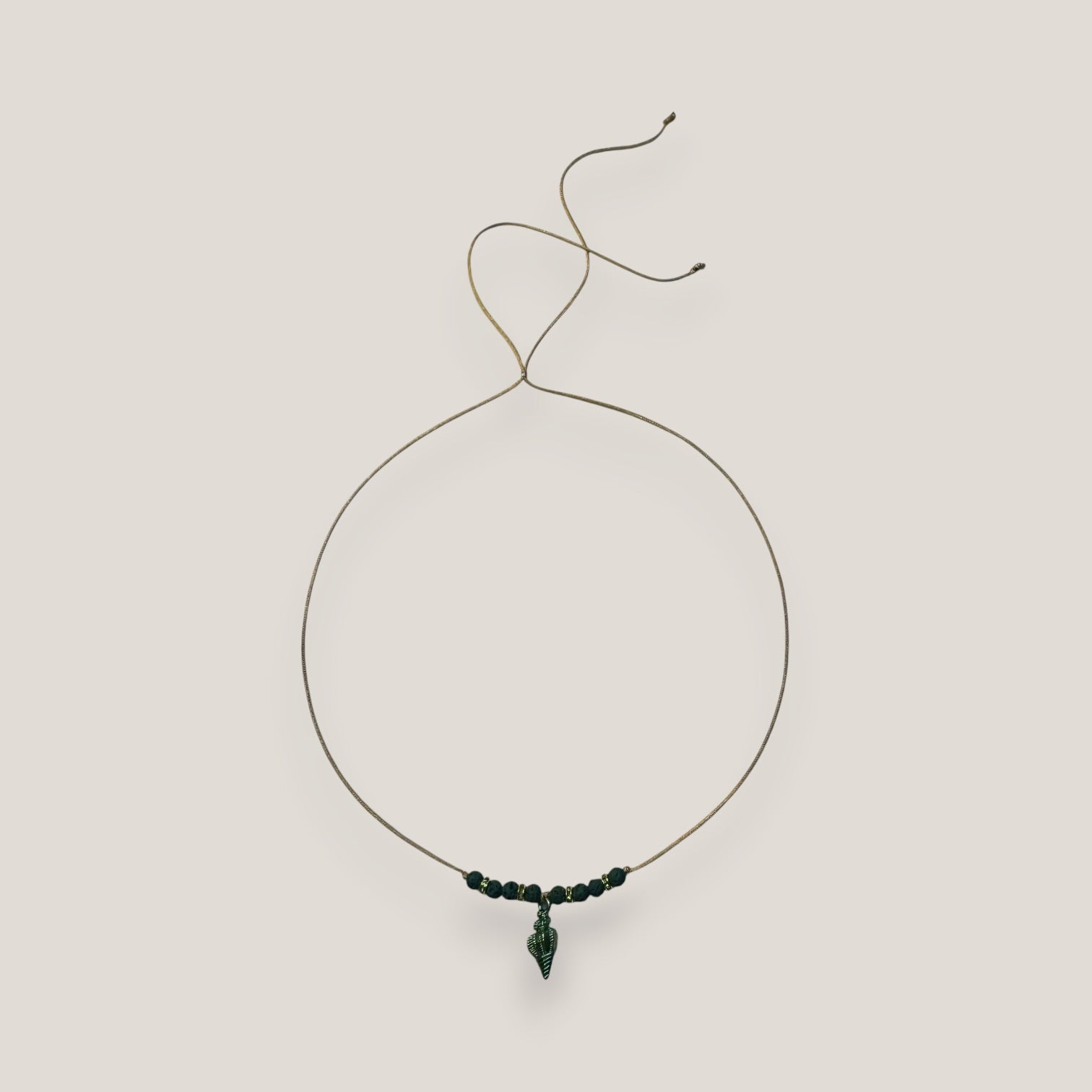 Collar midi con caracola dorada esmaltada en verde con lava verde oscuro y separadores dorados con cristalitos verde olivina