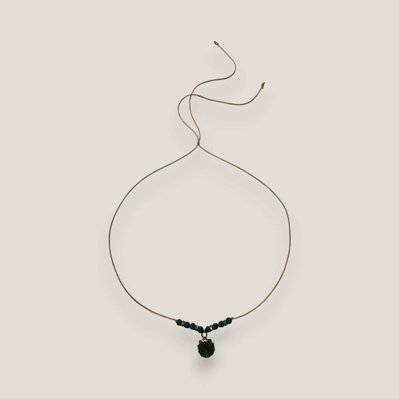 Collar midi con concha dorada esmaltada en verde con lava verde oscuro y separadores dorados con cristalitos verde olivina