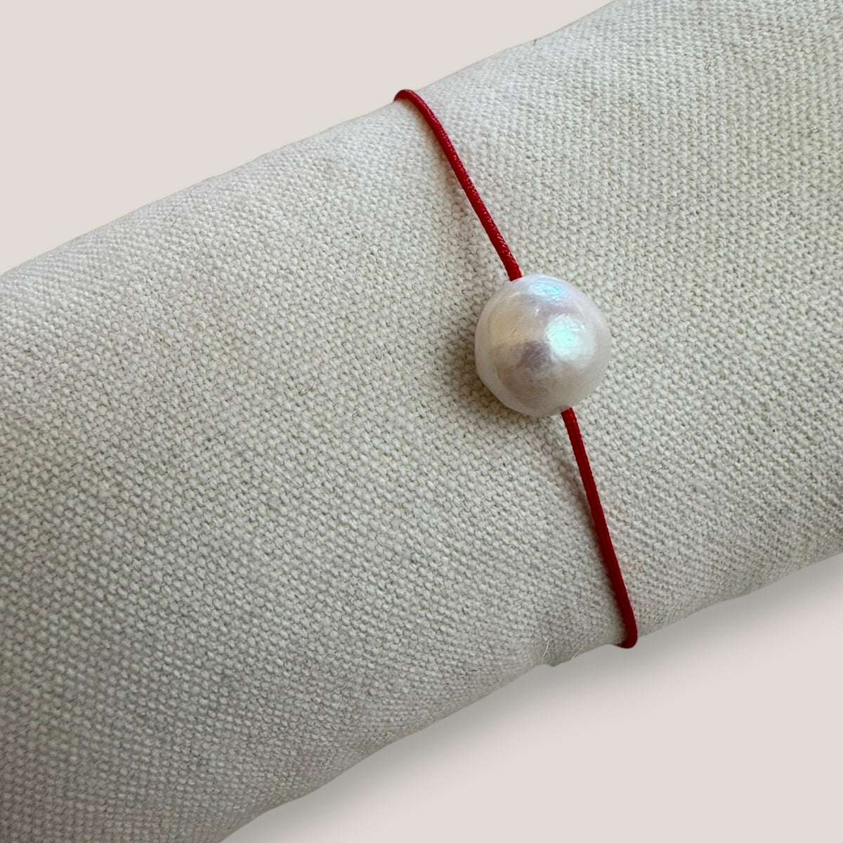 Pulsera minimal perla natural redondeada 10mm blanca cordón nailon rojo