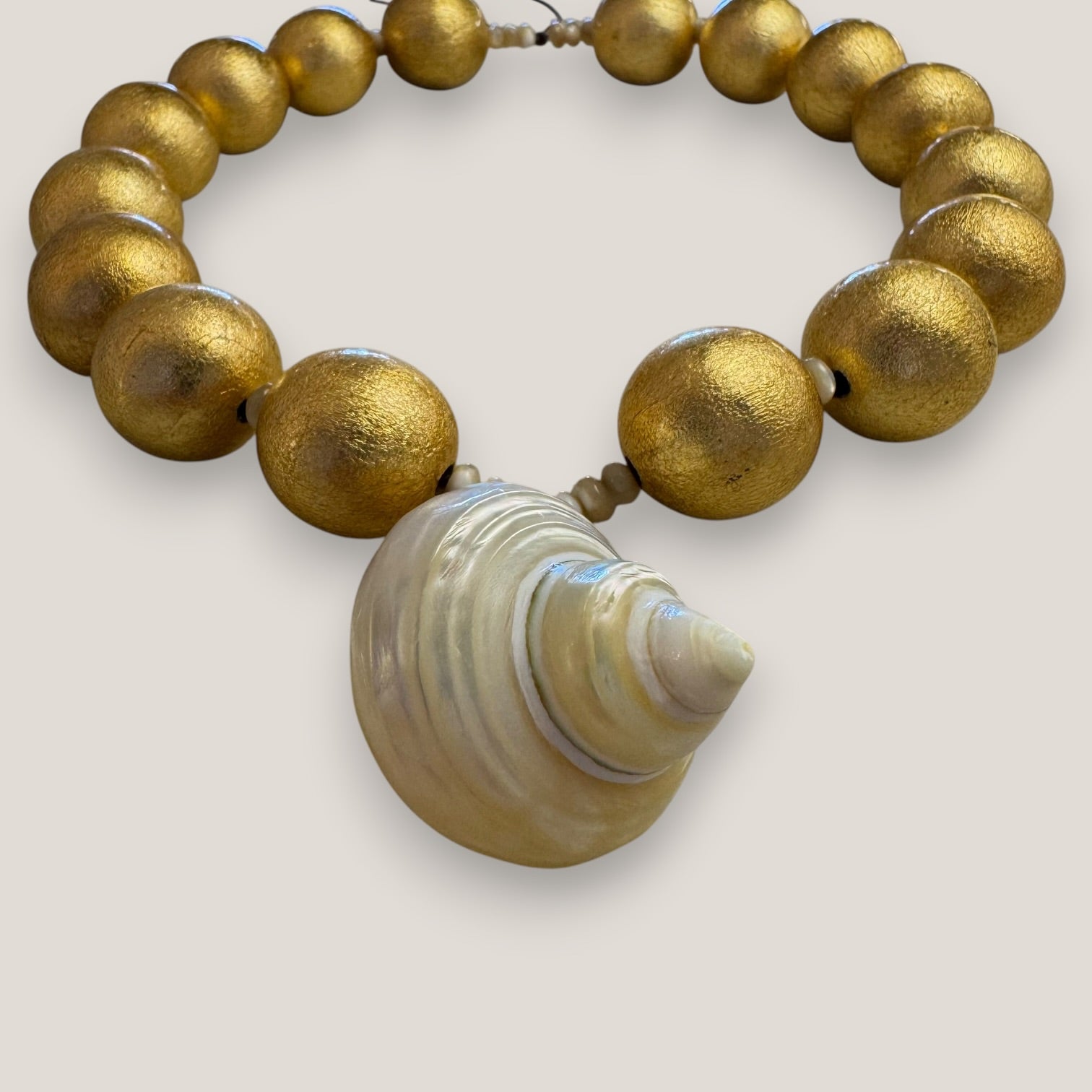 Collar gran caracola turbante nácar beis dorado cuentas madera pan de oro